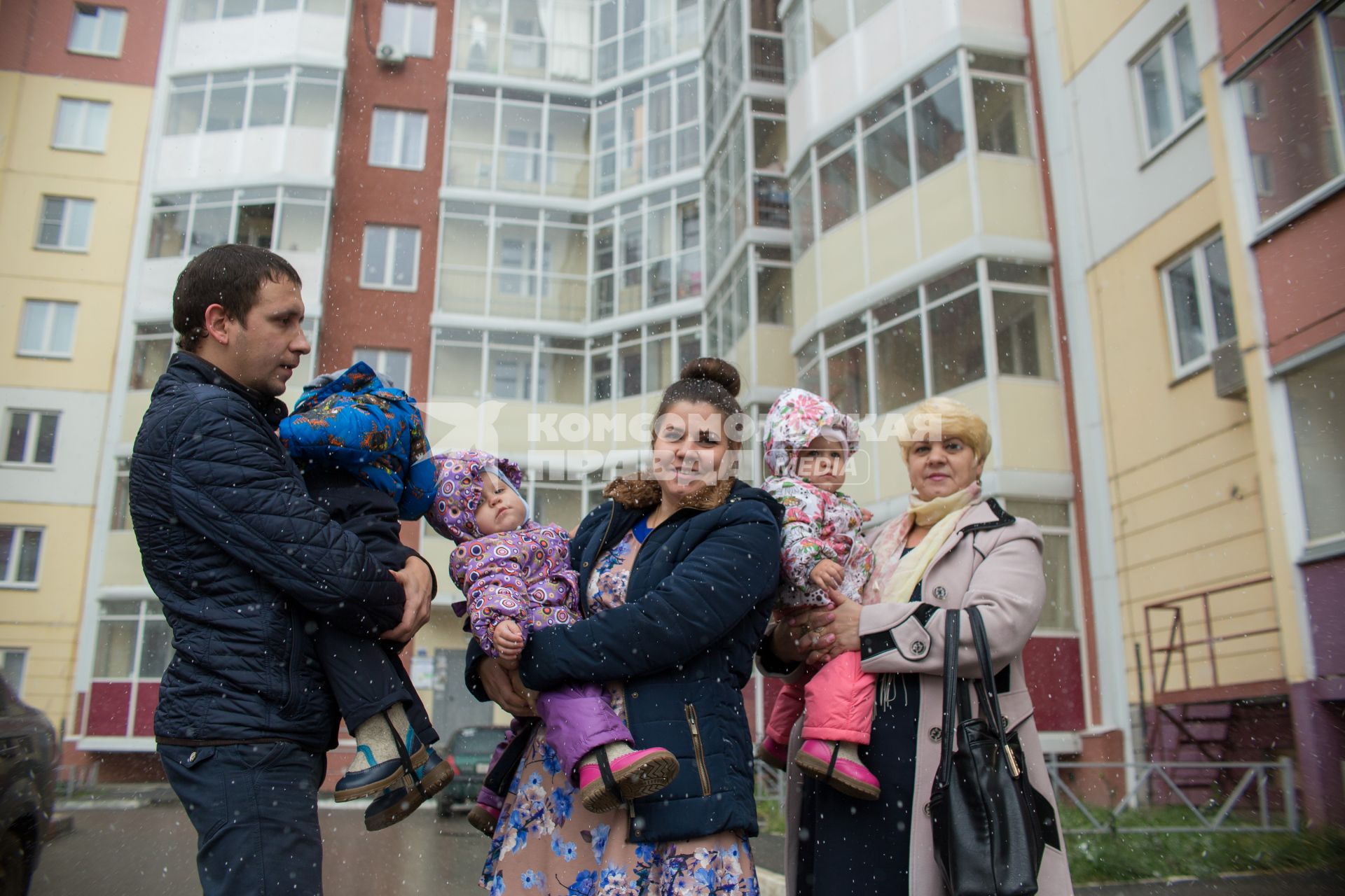 Челябинск.  Многодетная семья новоселов   рядом с домом, в котором    они получили новую квартиру.