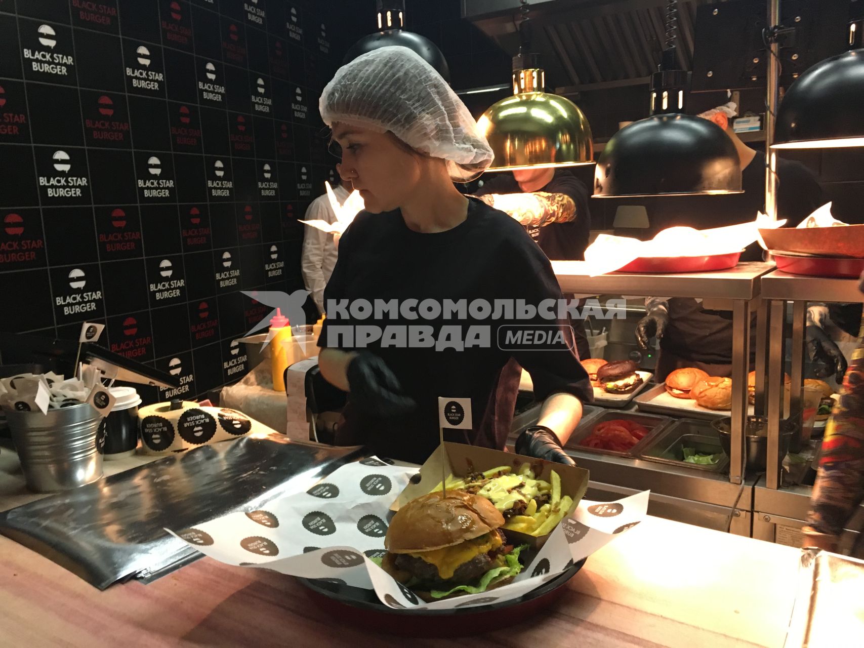 Москва. Сотрудница с подносом  в бургерной `Black Star Burger`, которую  открыл рэпер Тимати на Новом Арбате.