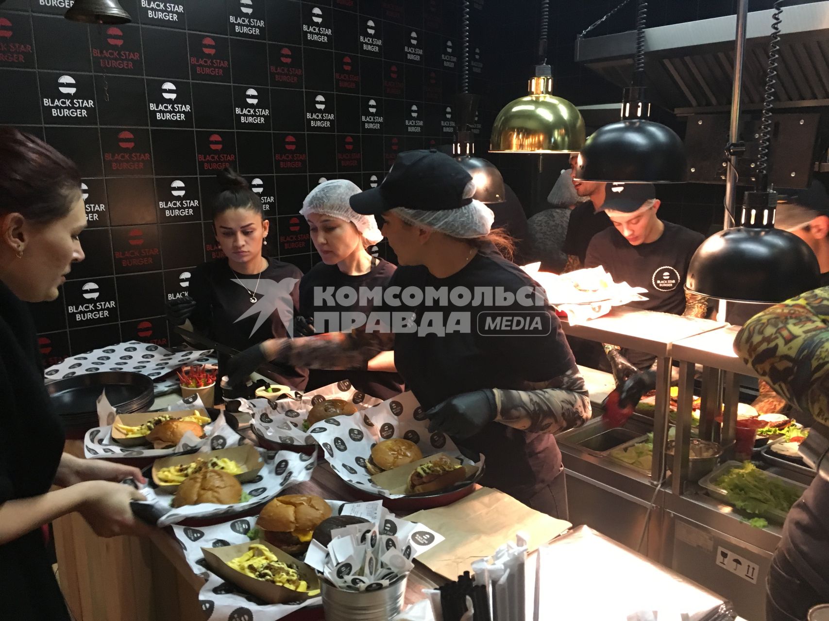 Москва.  Сотрудницы и повара  бургерной `Black Star Burger`, которую  открыл рэпер Тимати на Новом Арбате.