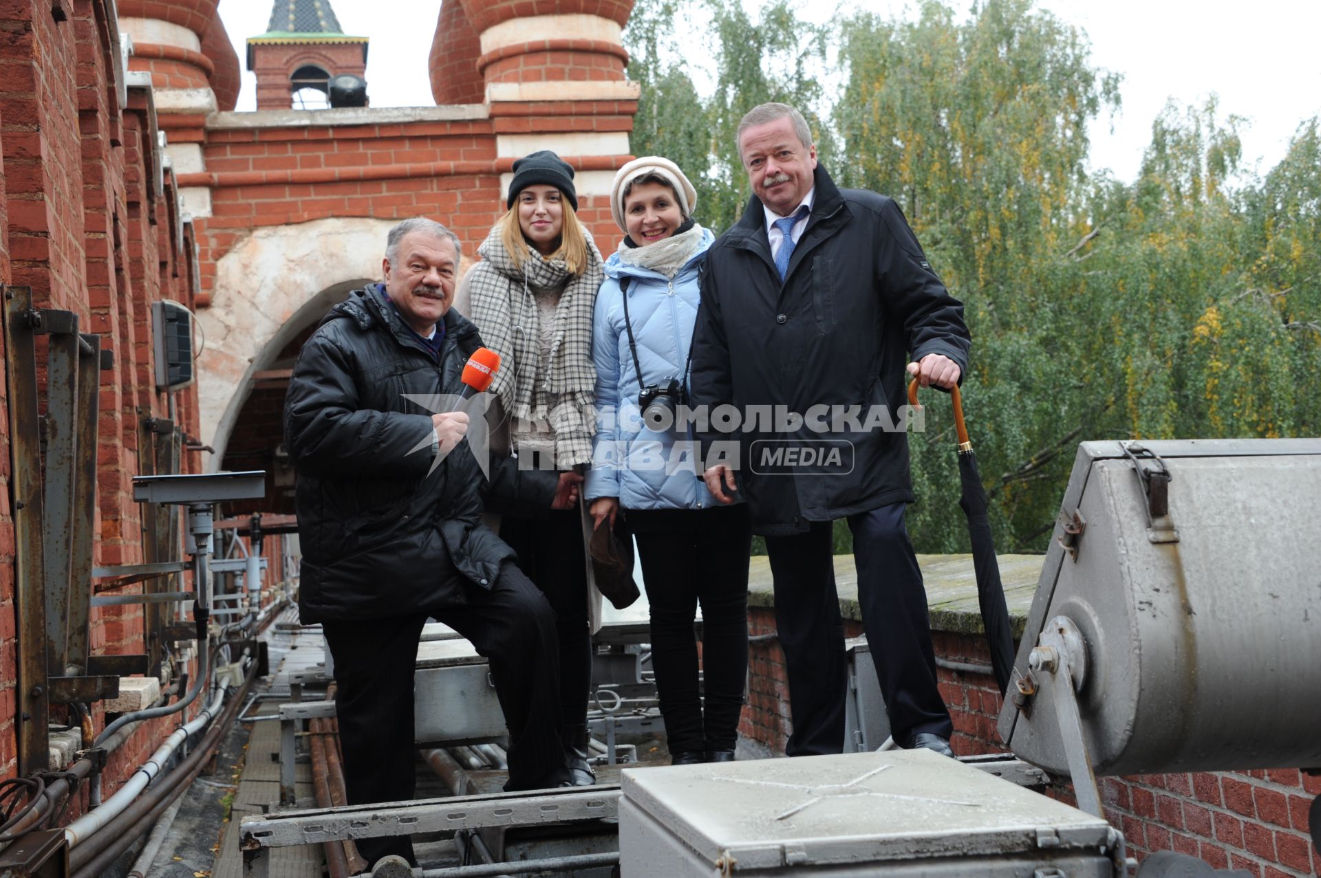 Москва. Корреспонденты `Комсомольской правды` Александр Гамов (слева), Наталия Андреассен (вторая справа), видеоператор Елизавета Совцова (вторая слева) и советник директора ФСО РФ Сергей Девятов на Кремлевской стене.