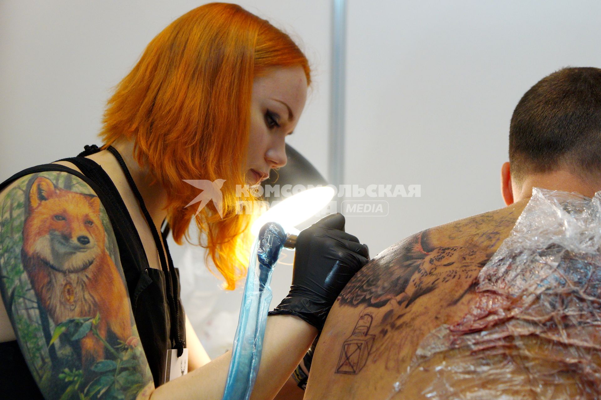 Екатеринбург. Уральский фестиваль искусства татуировки \'Ural tattoo convention 2016\'. Тату-мастер набивает татуировку посетителю фестиваля