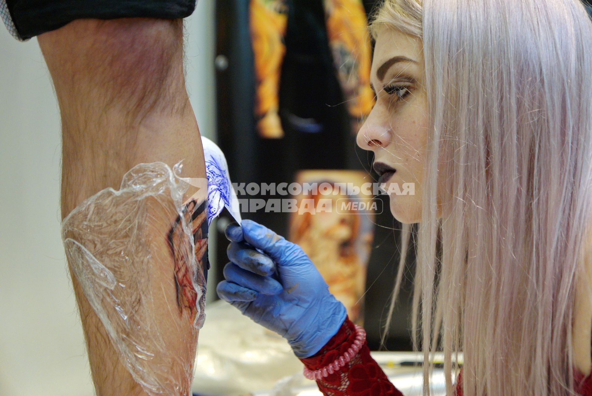 Екатеринбург. Уральский фестиваль искусства татуировки \'Ural tattoo convention 2016\'. Тату-мастер переводит татуировку посетителю фестиваля