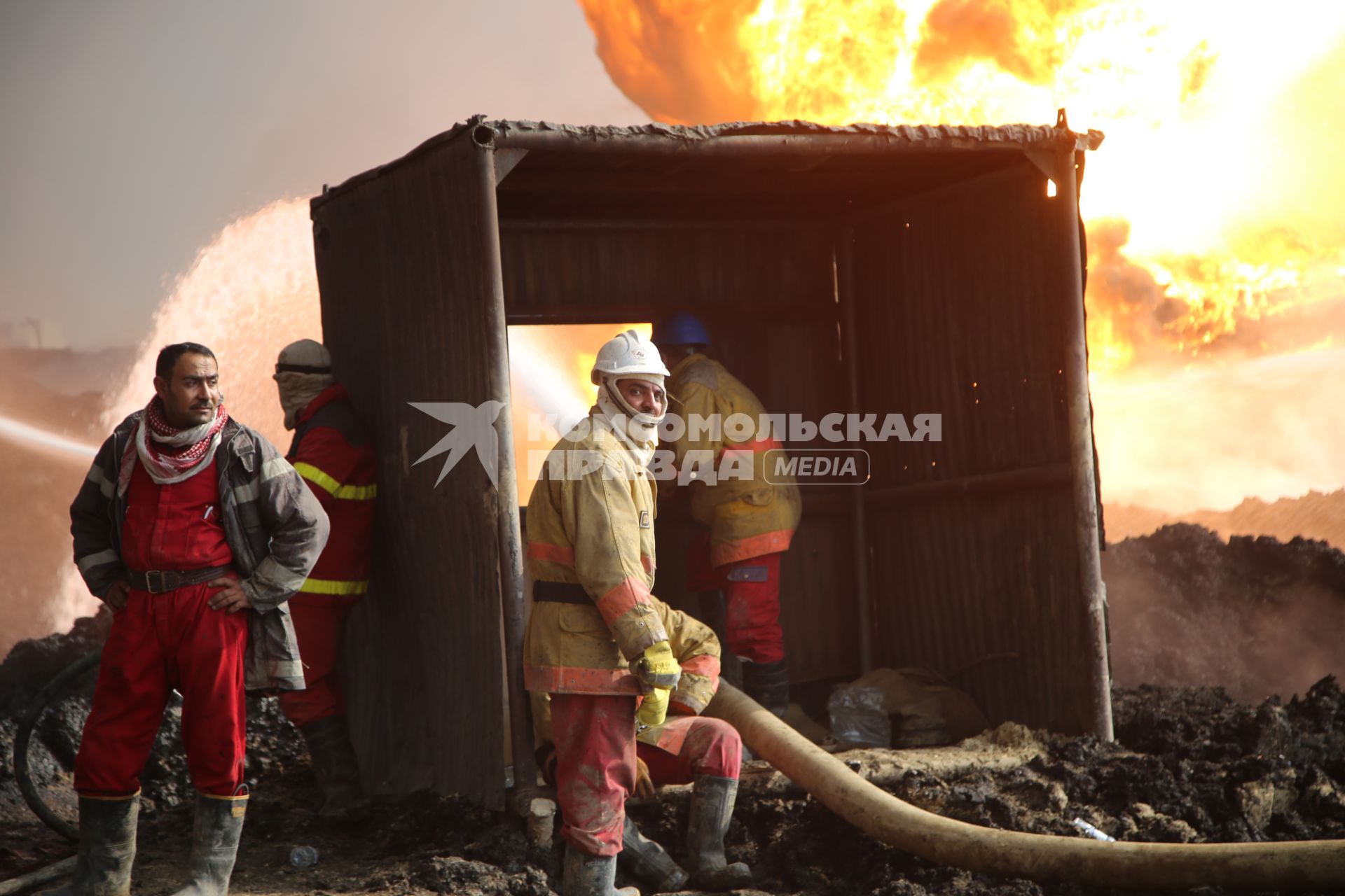 Ирак, Кайара. Пожарные заливают водой горящие нефтяные скважины, подожженные отступающими к Мосулу боевиками `Исламского Государства` (запрещенная в России экстремистская организация).