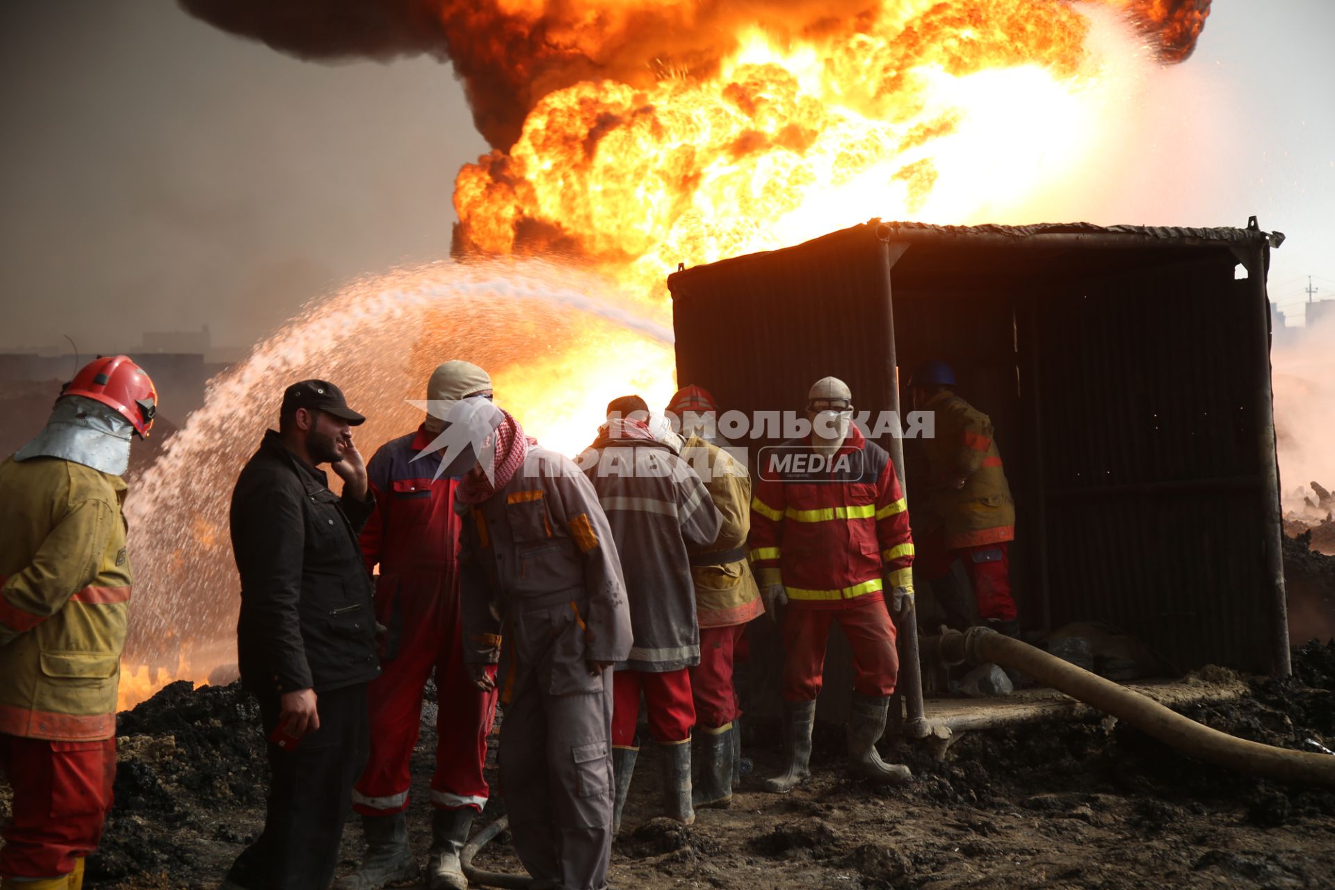 Ирак, Кайара. Пожарные заливают водой горящие нефтяные скважины, подожженные отступающими к Мосулу боевиками `Исламского Государства` (запрещенная в России экстремистская организация).