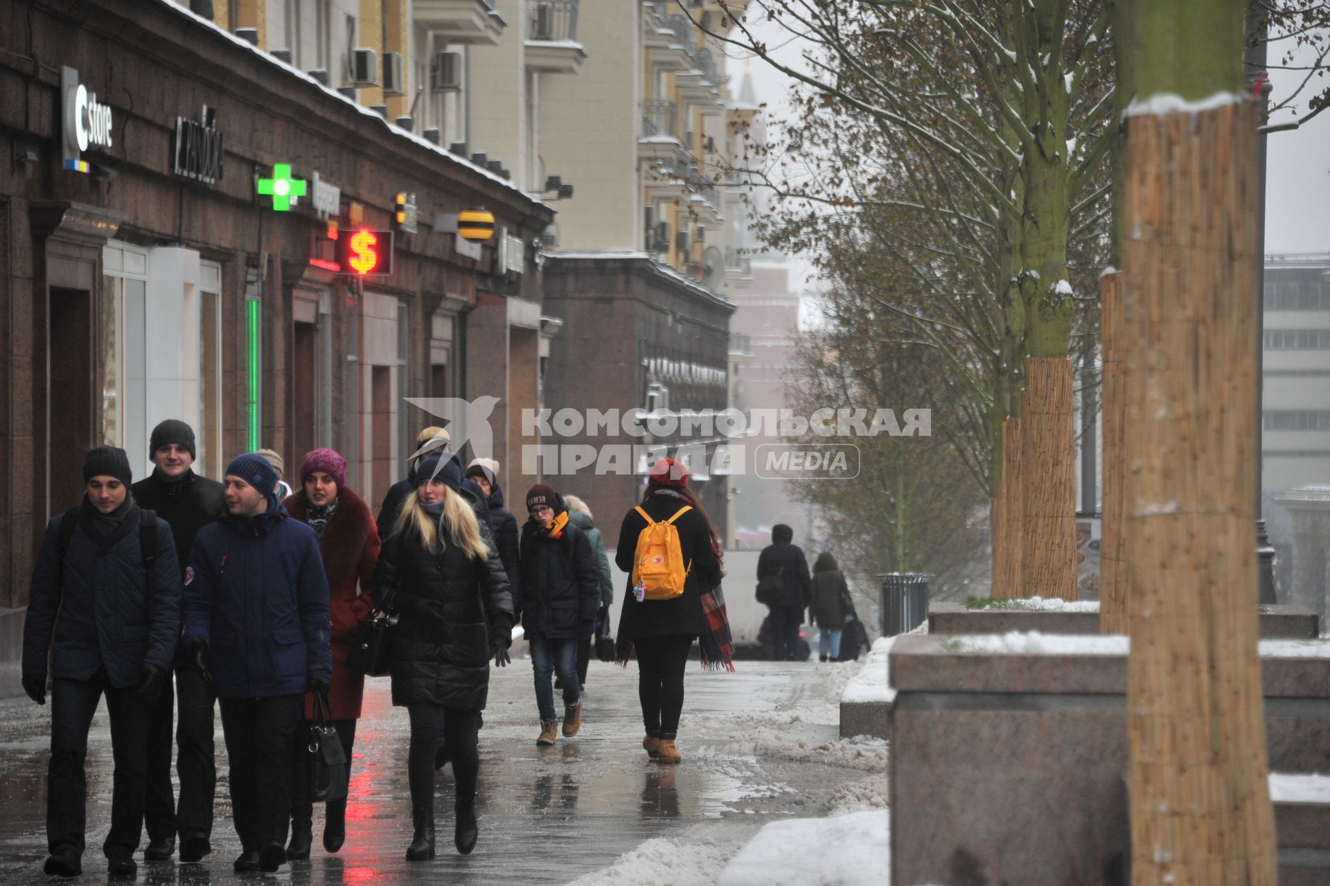 Москва.   Пешеходы идут по заснеженной Тверской улице.