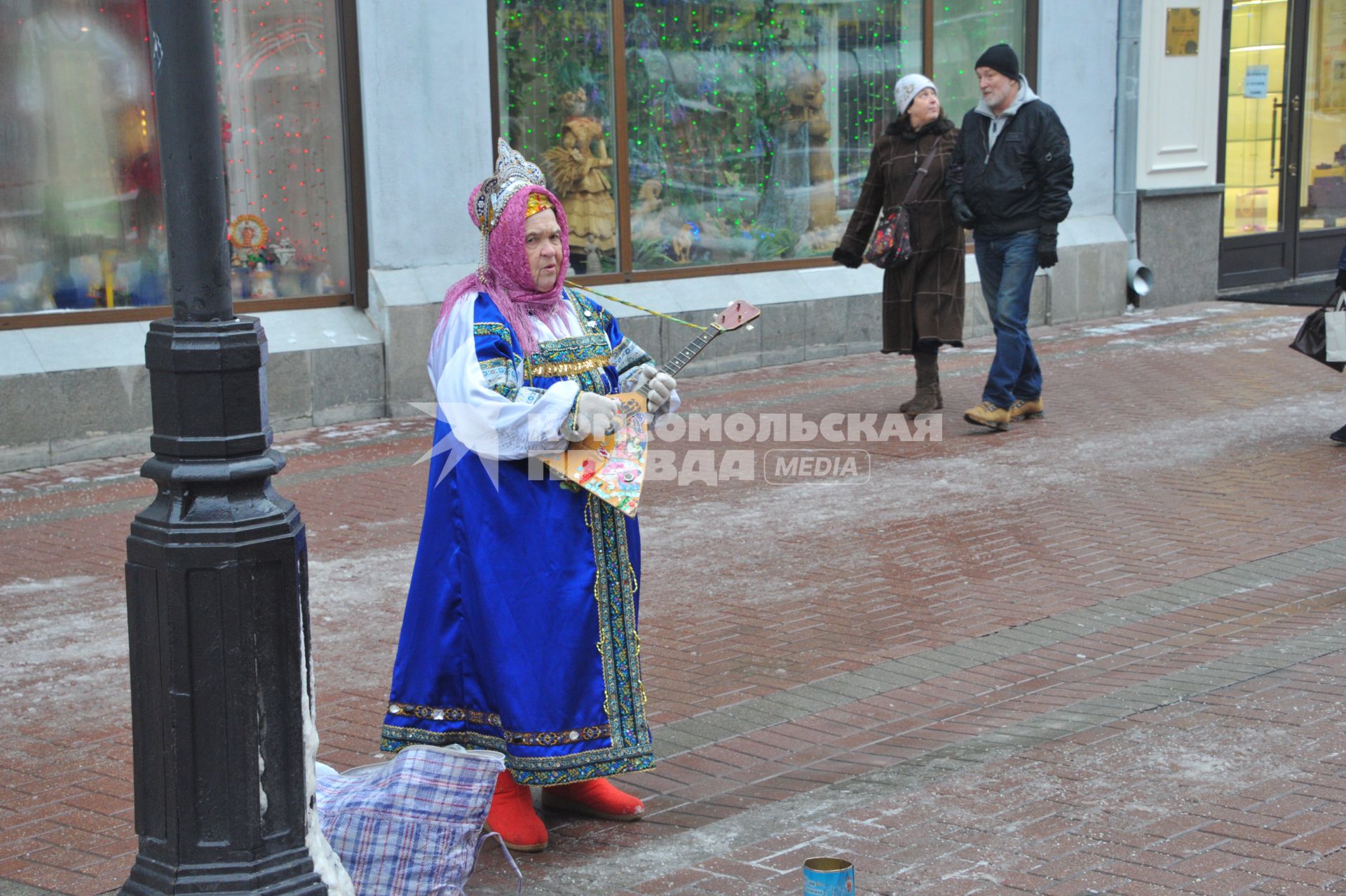 Москва. Женщина в народном костюме играет на балалайке.