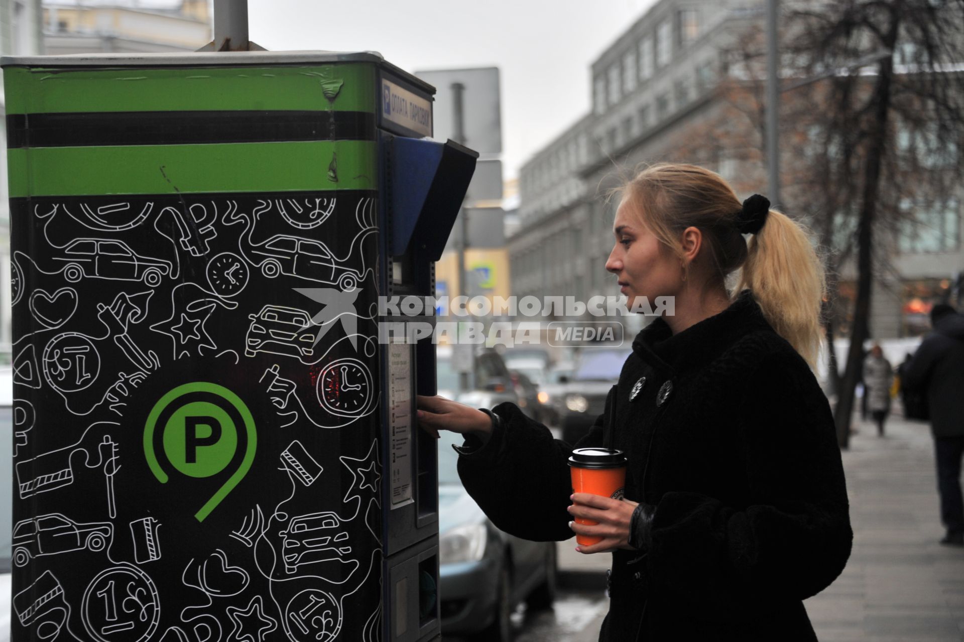 Москва. Девушка оплачивает парковку автомобиля через паркомат.