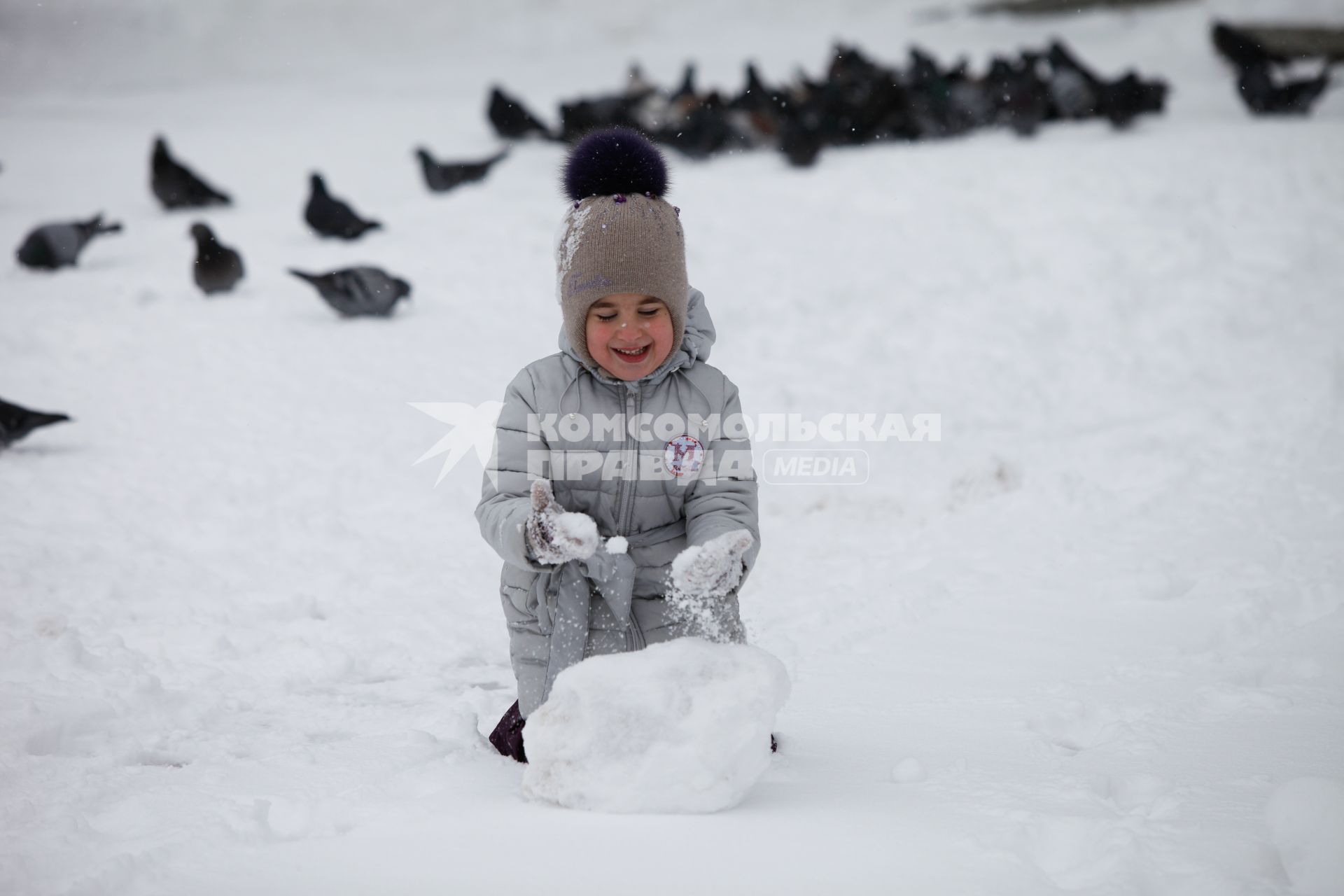 Ставрополь. Девочка лепит снежный ком.