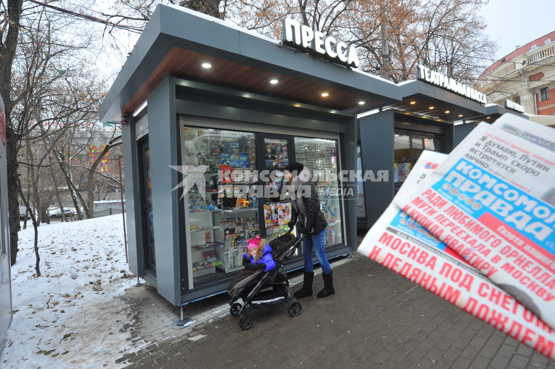 Москва.  Женщина с коляской у обновленного киоска `Пресса`  рядом с метро Краснопресненская.