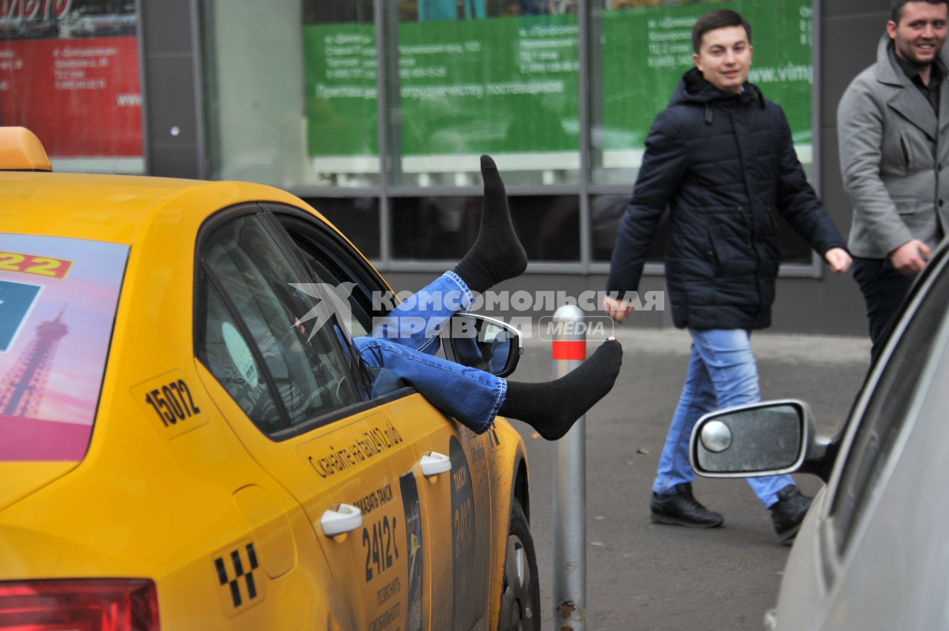 Москва.  Водитель такси отдыхает в автомобиле.