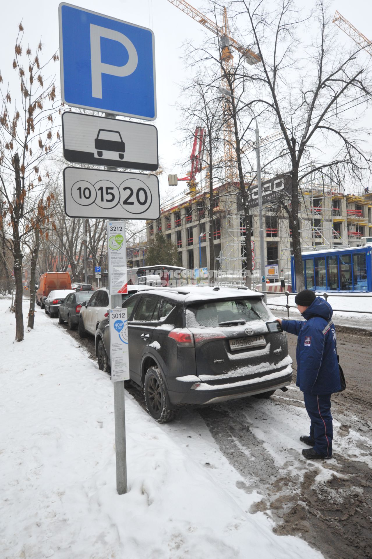 Москва. Пеший инспектор `Администрации московского парковочного пространства` проверяет оплату парковки.