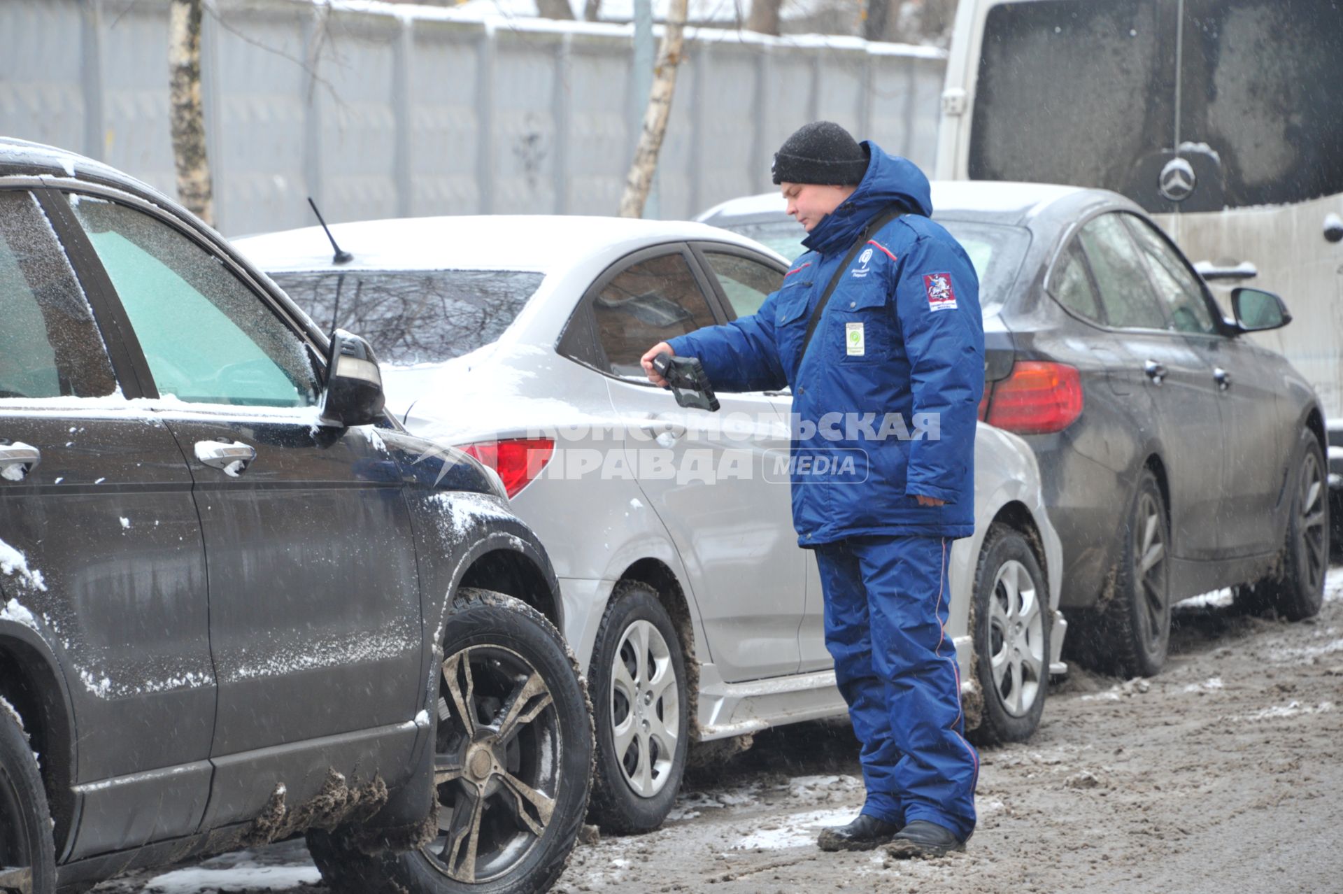 Москва. Пеший инспектор `Администрации московского парковочного пространства` проверяет оплату парковки.