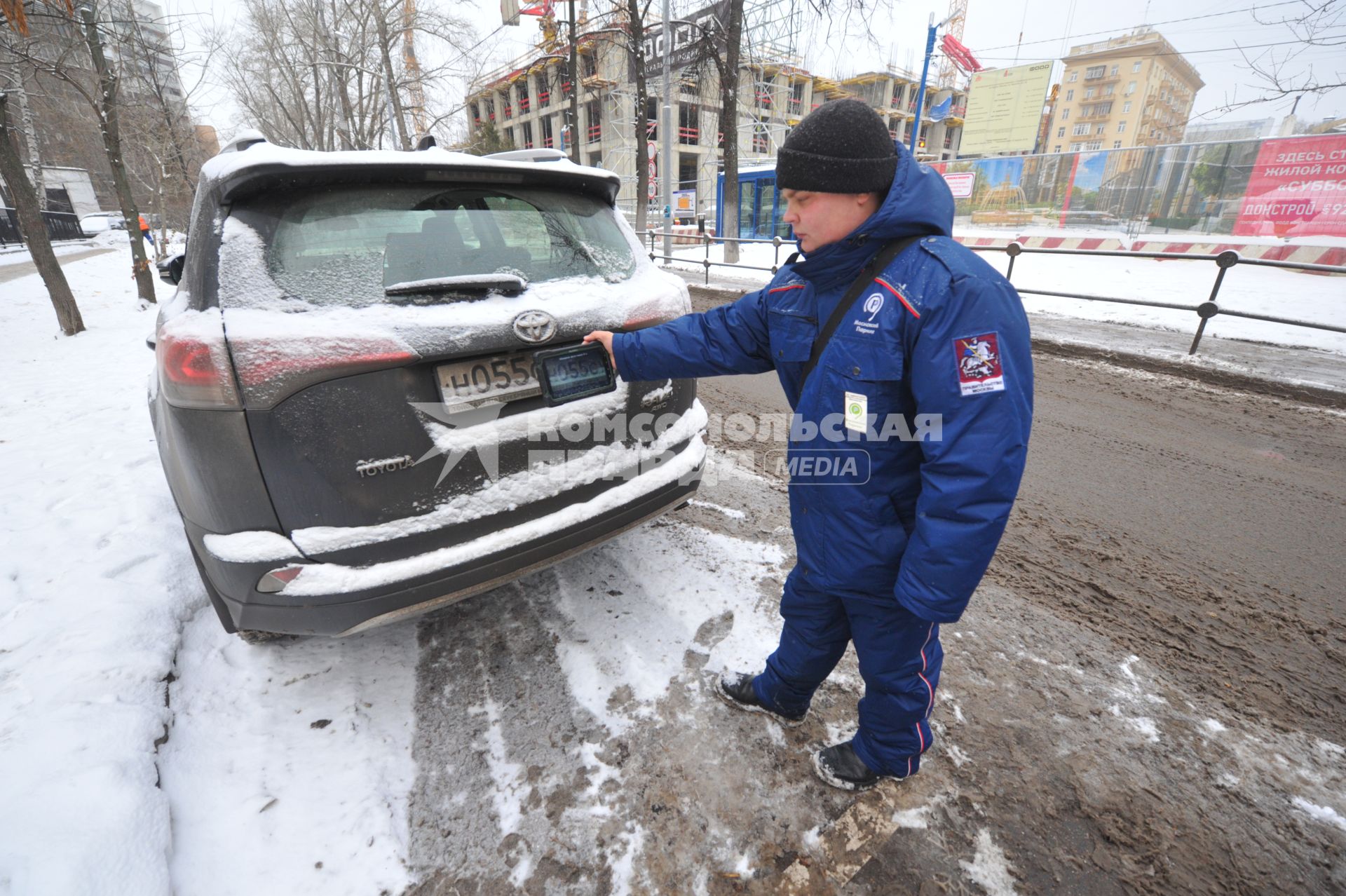 Москва. Пеший инспектор `Администрации московского парковочного пространства` проверяет оплату парковки.