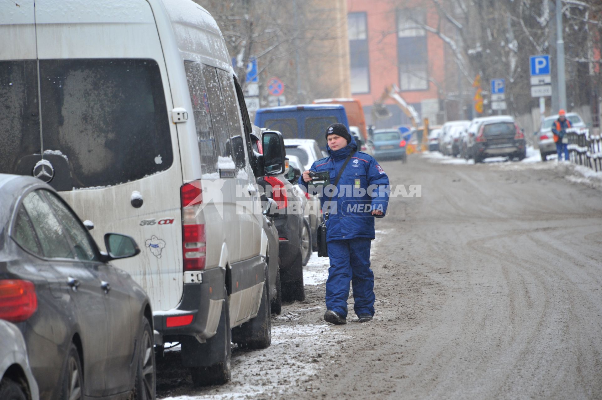 Москва. Пеший инспектор `Администрации московского парковочного пространства` проверяет оплату парковки.