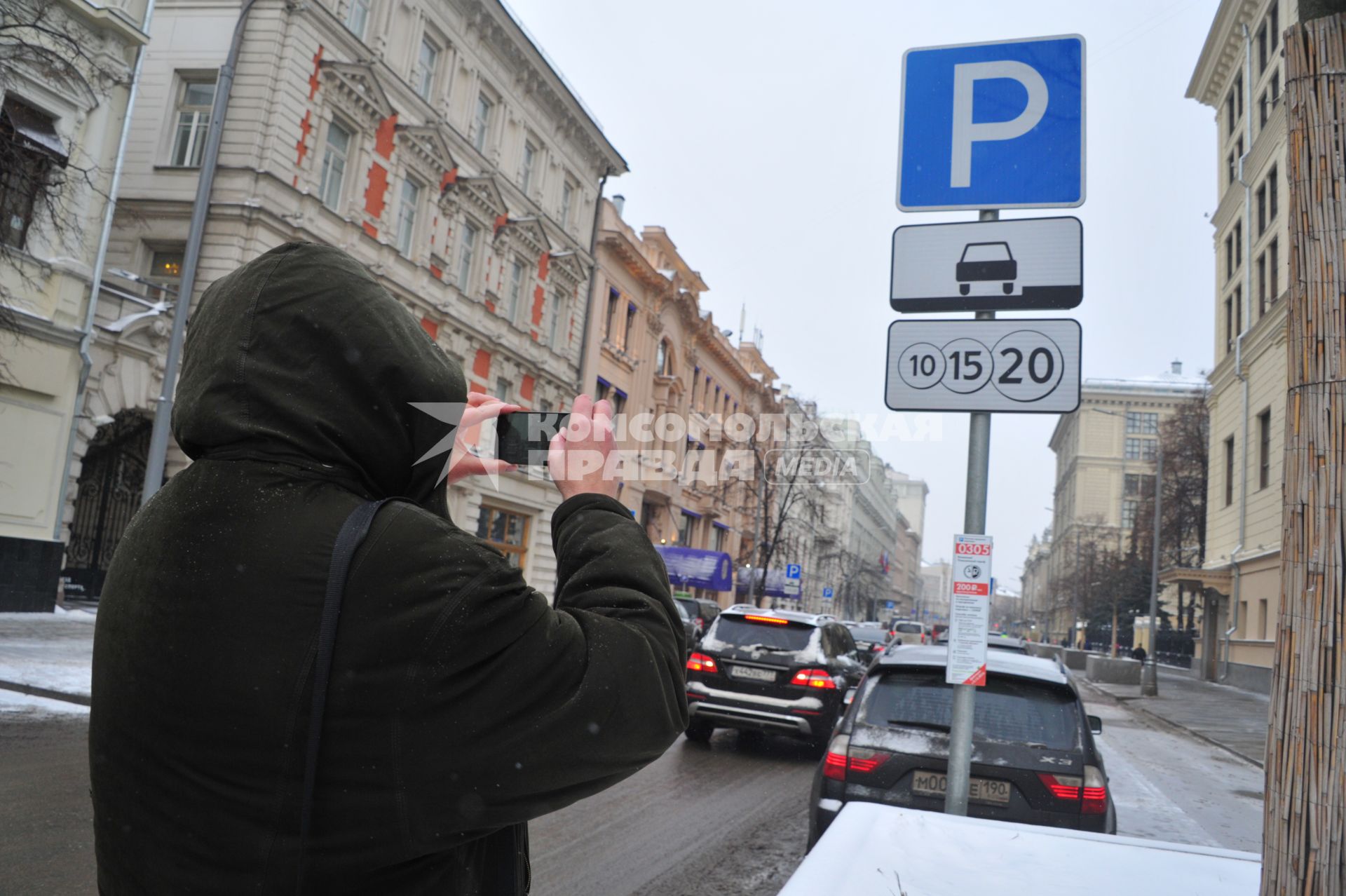 Москва. Мужчина фотографирует информационный знак с новыми тарифами на платную парковку в центре города. Со 2 декабря 2016 года тариф на платную парковку изменится на 732 улицах Москвы и будет составлять от 50 рублей за первые полчаса до 200 рублей в час.