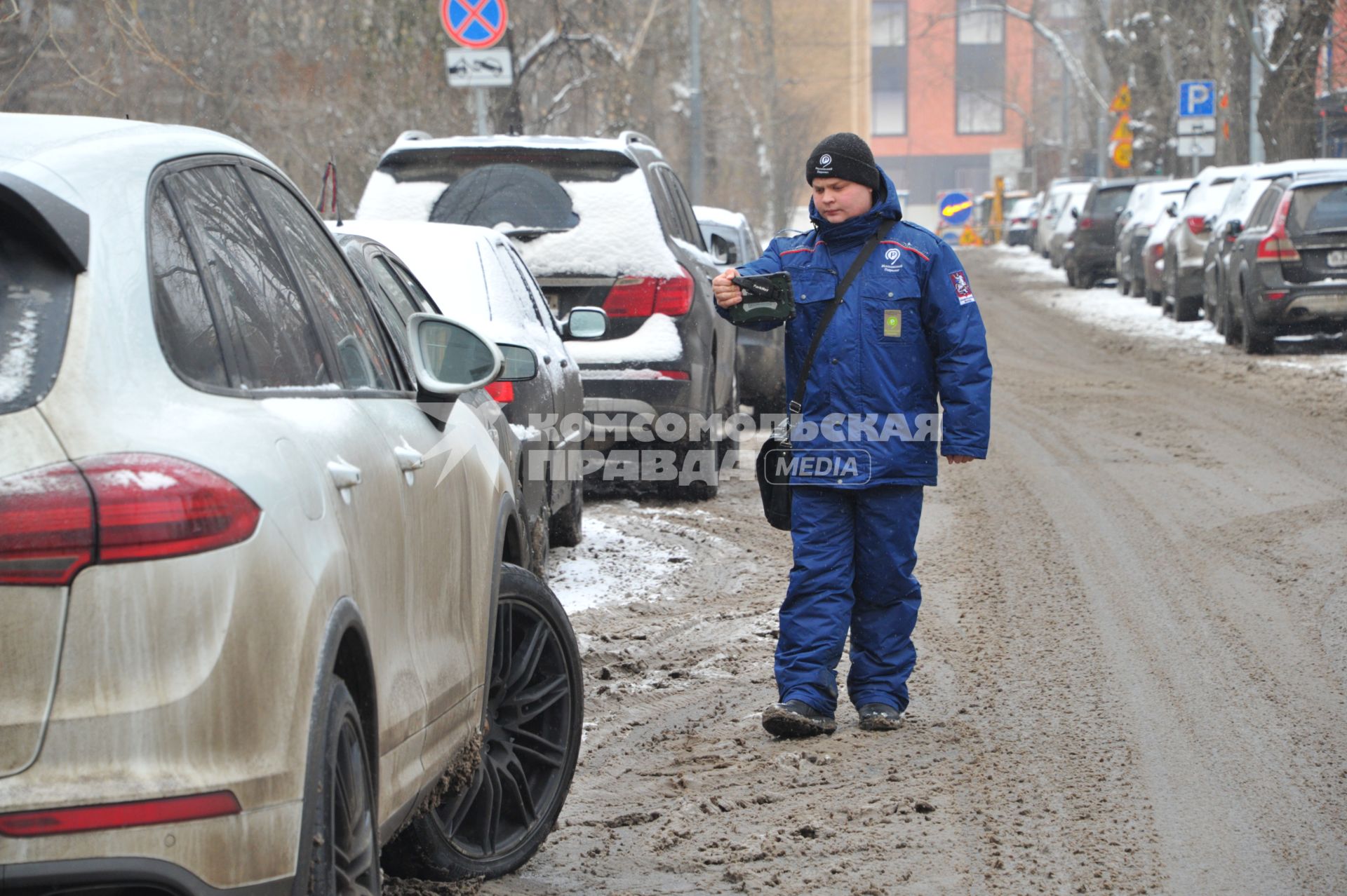 Москва. Пеший инспектор `Администрации московского парковочного пространства` проверяет оплату парковки.