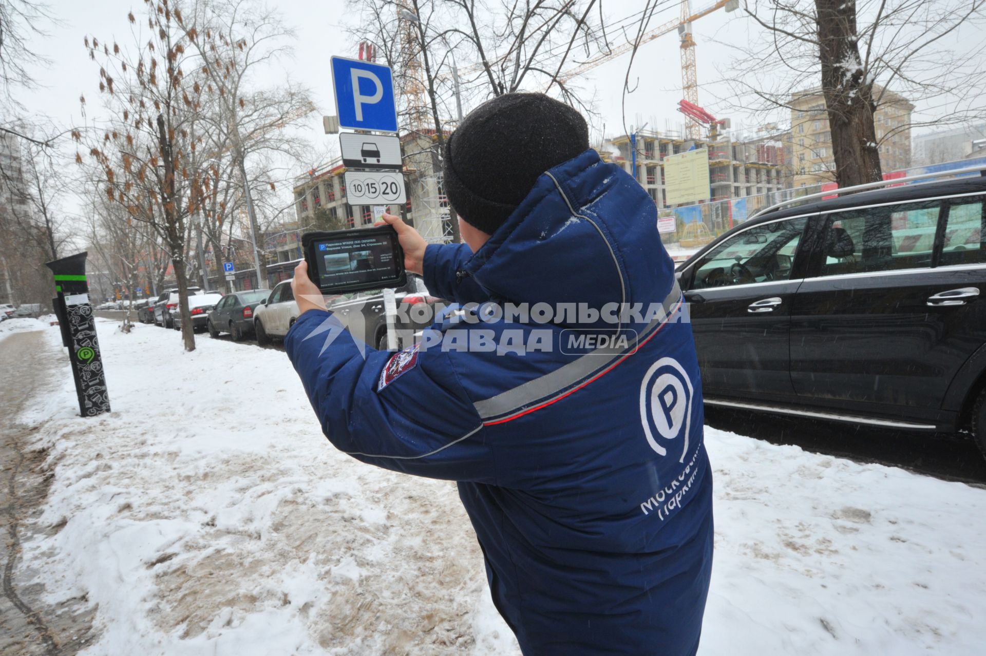 Москва. Пеший инспектор `Администрации московского парковочного пространства` проверяет оплату парковки.