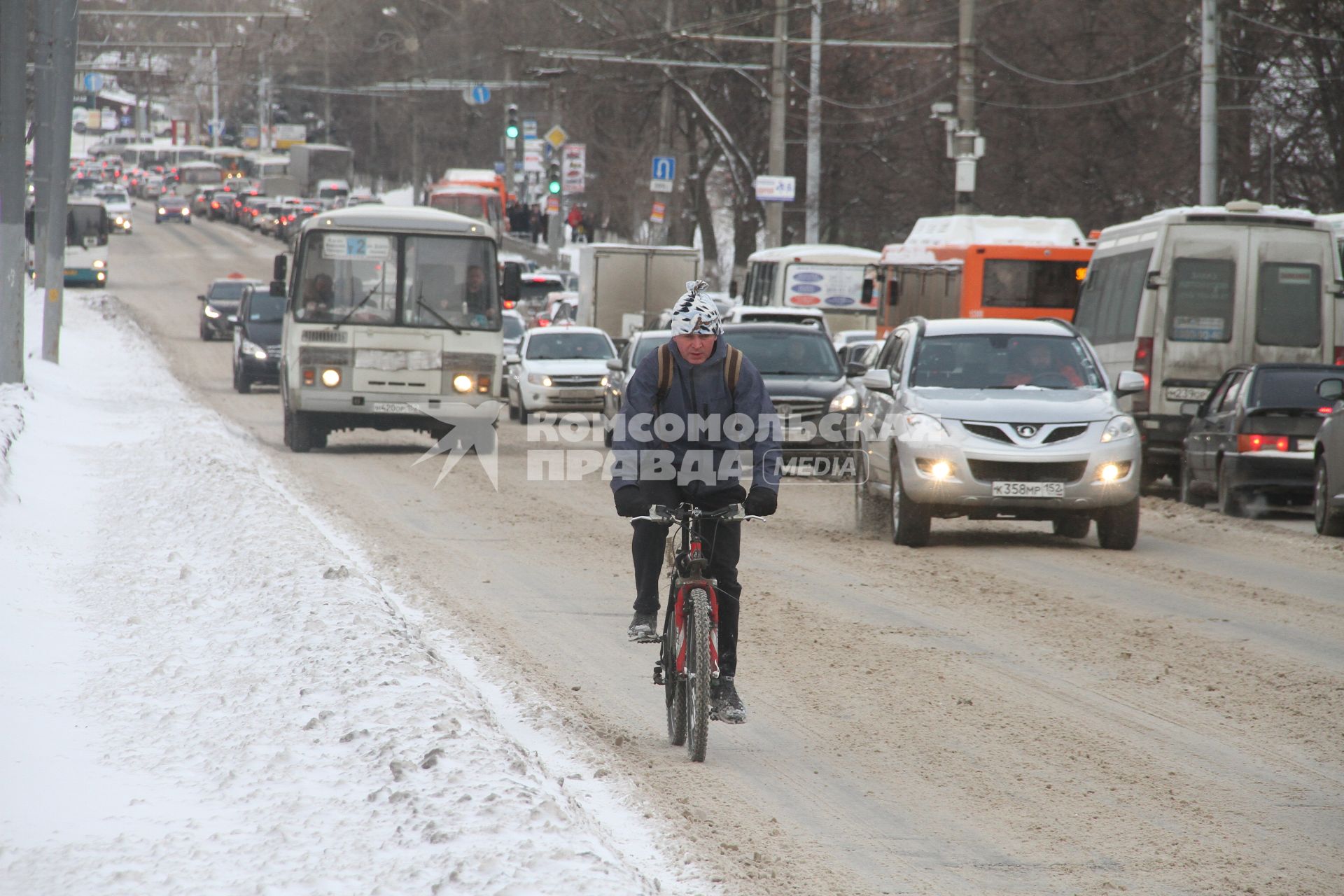 Нижний Новгород. Велосипедист едет по автомобильной дороге на одной из улиц города.