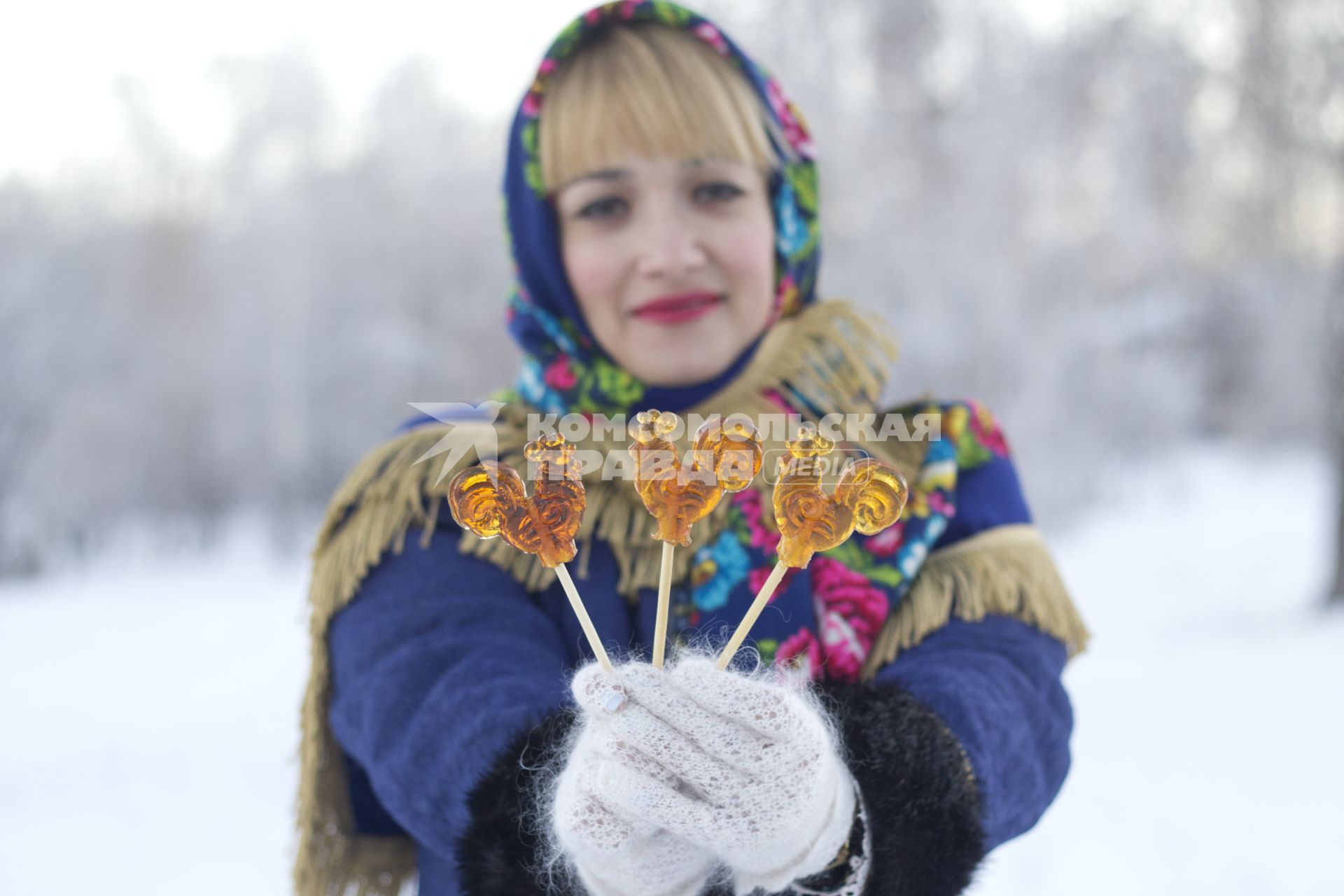 Иркутск. Девушка держит в руках леденцы в форме петушка.