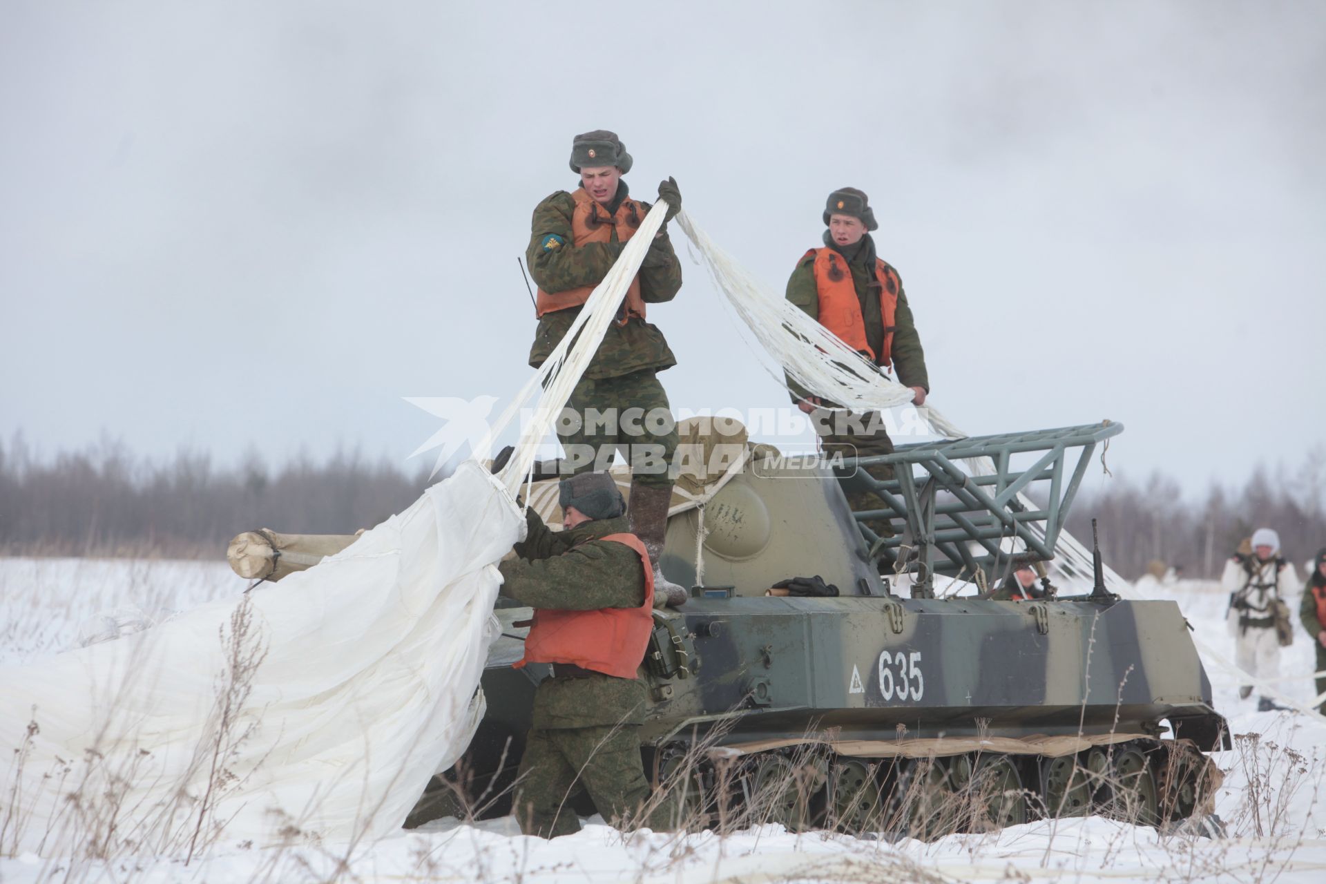 Рязанская область. Военнослужащие 106-й гвардейской Воздушно-десантной Краснознаменной ордена Кутузова дивизии   убирают парашют с самоходного артиллерийского орудия `НОНА` после его приземления.