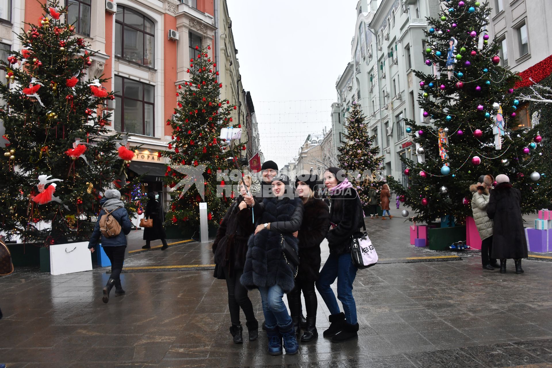 Москва. Молодые люди фотографируются у новогодних елей на одной из улиц города.