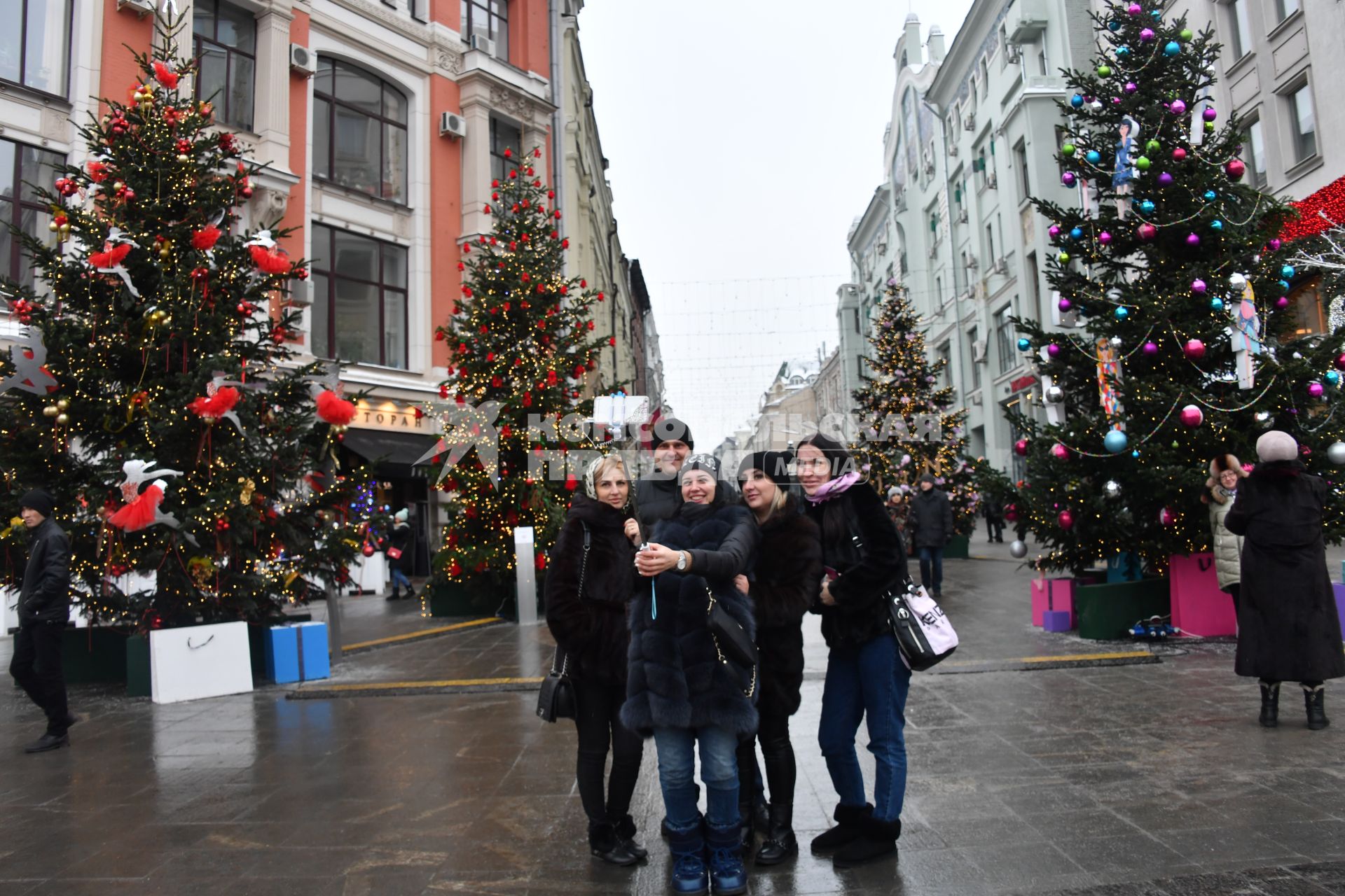 Москва. Молодые люди фотографируются у новогодних елей на одной из улиц города.