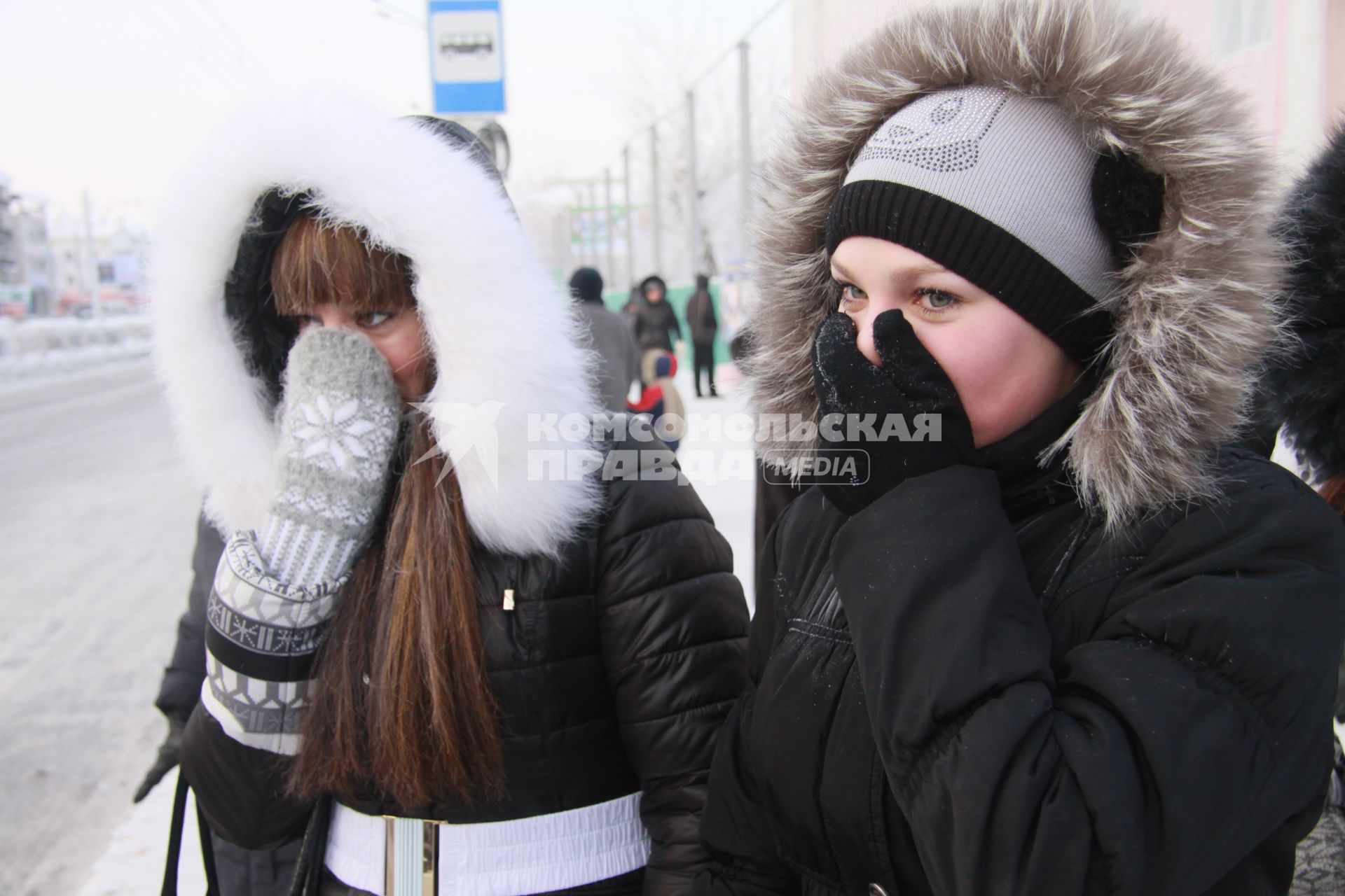 Барнаул. Девушки на улице  закрывают лица от холода.