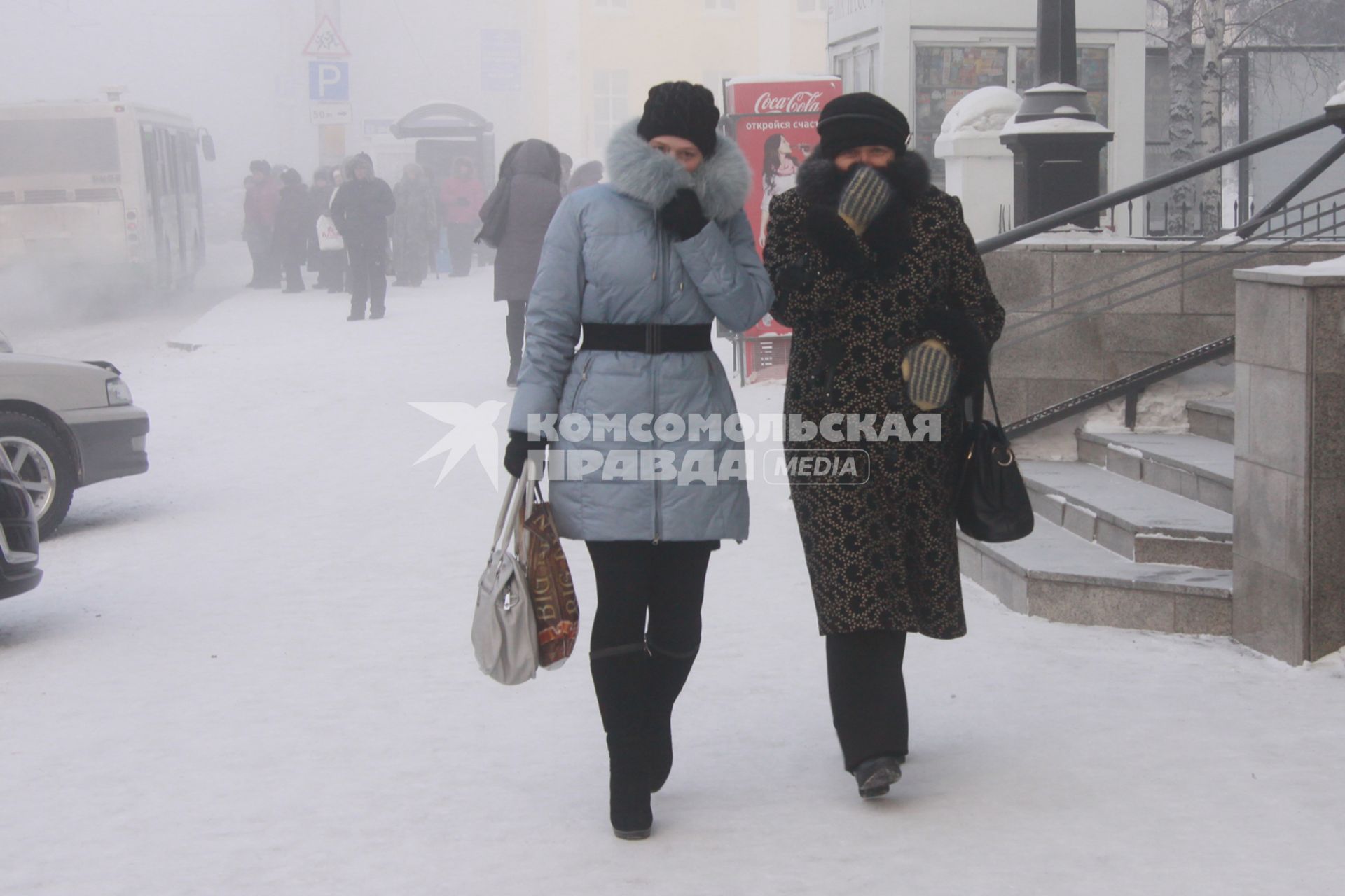 Барнаул. Девушки на улице  закрывают лица от холода.