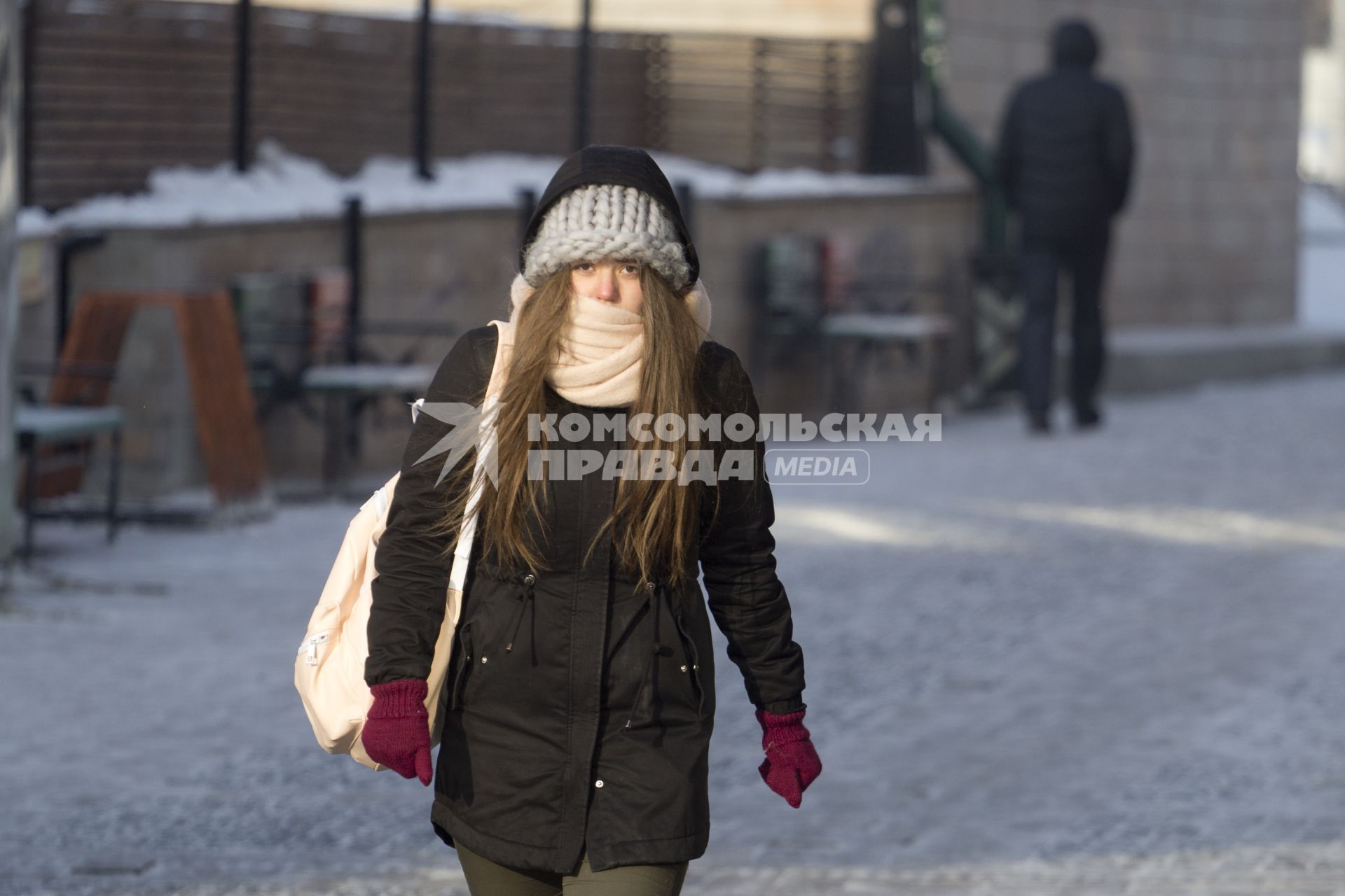 Иркутск. Девушка на улице закрыла лицо от холода.