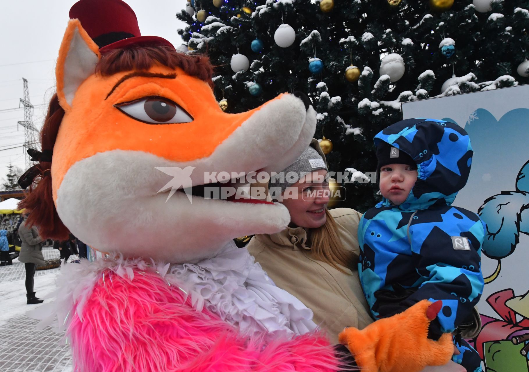 Москва.  Ростовая кукла Лиса и ребенок  у Новогодней елки.