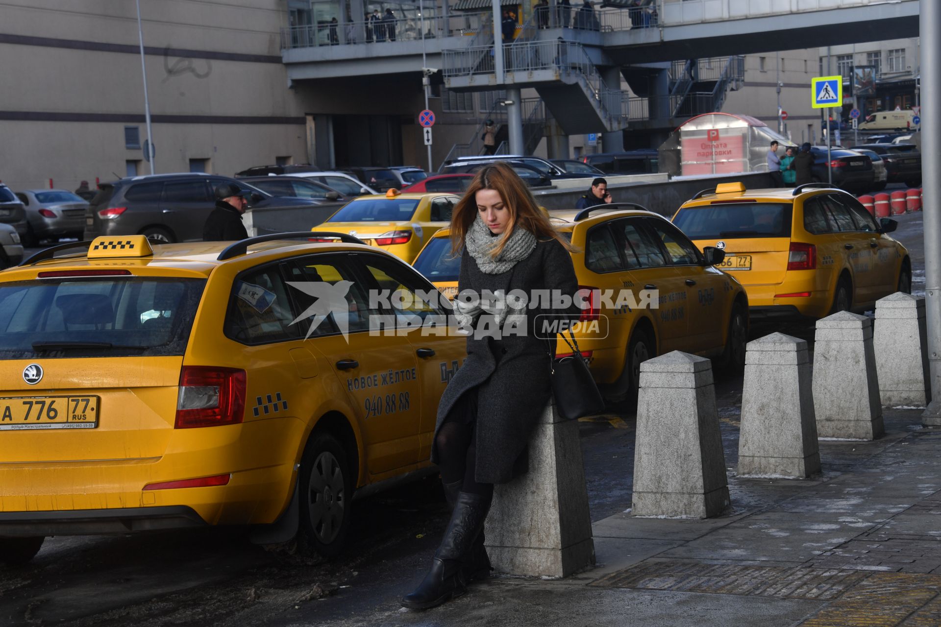 Москва. Девушка вызывает такси при помощи приложения, установленного в планшете.