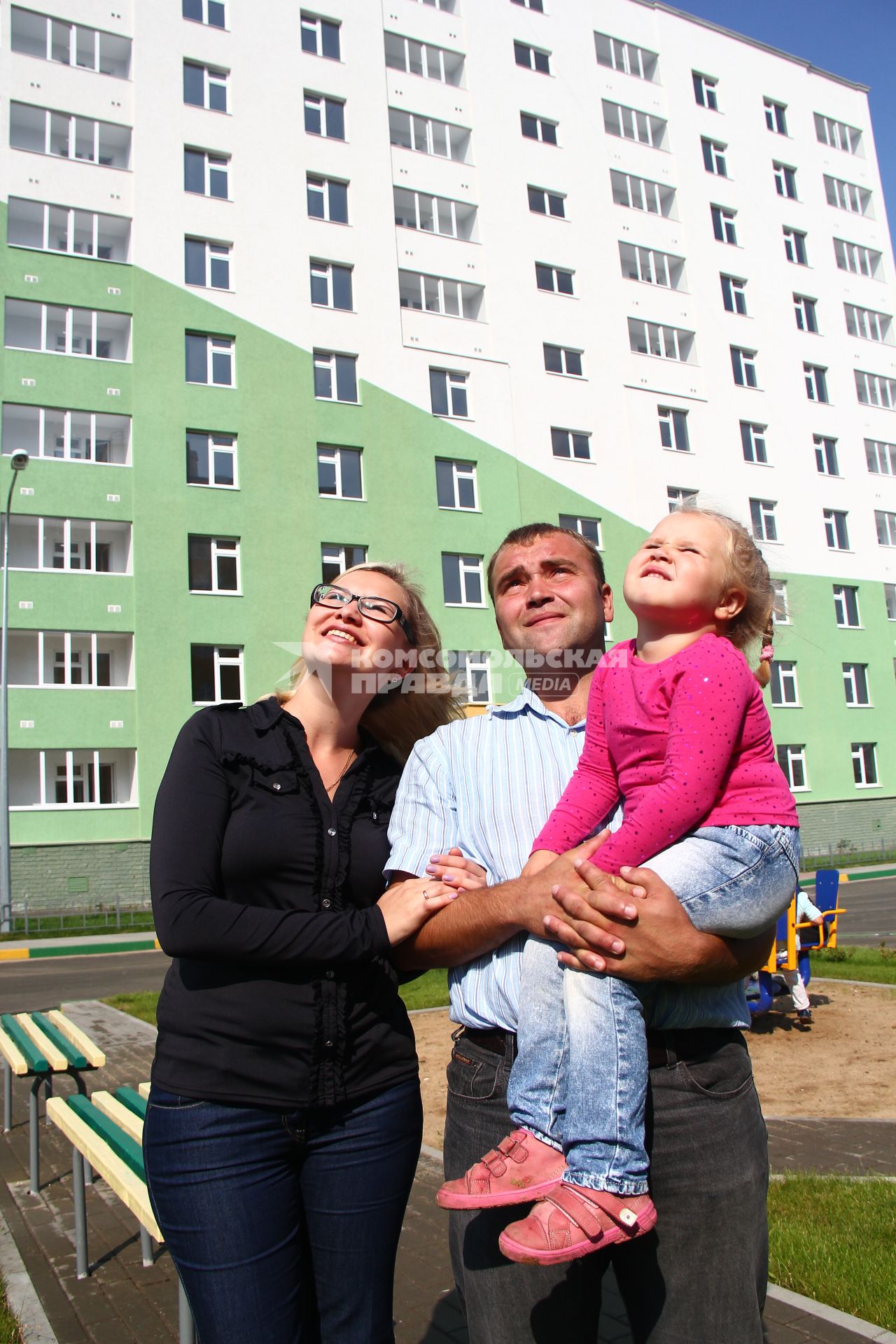 Нижний Новгород. Женщина и мужчина с ребенком смотрят на новостройку.