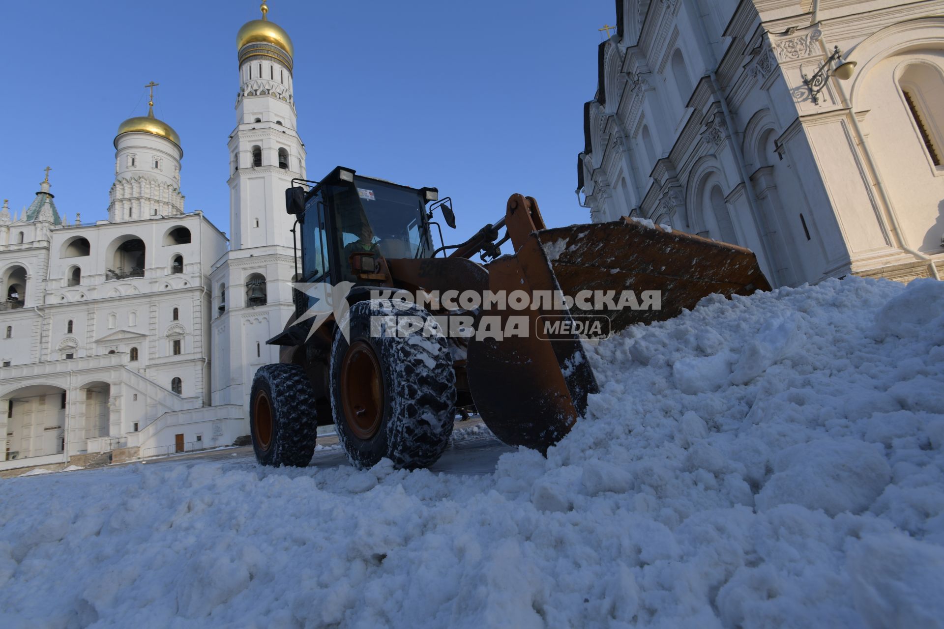 Москва.  Уборка снега на соборной площади Кремля у колокольни Ивана Великого.