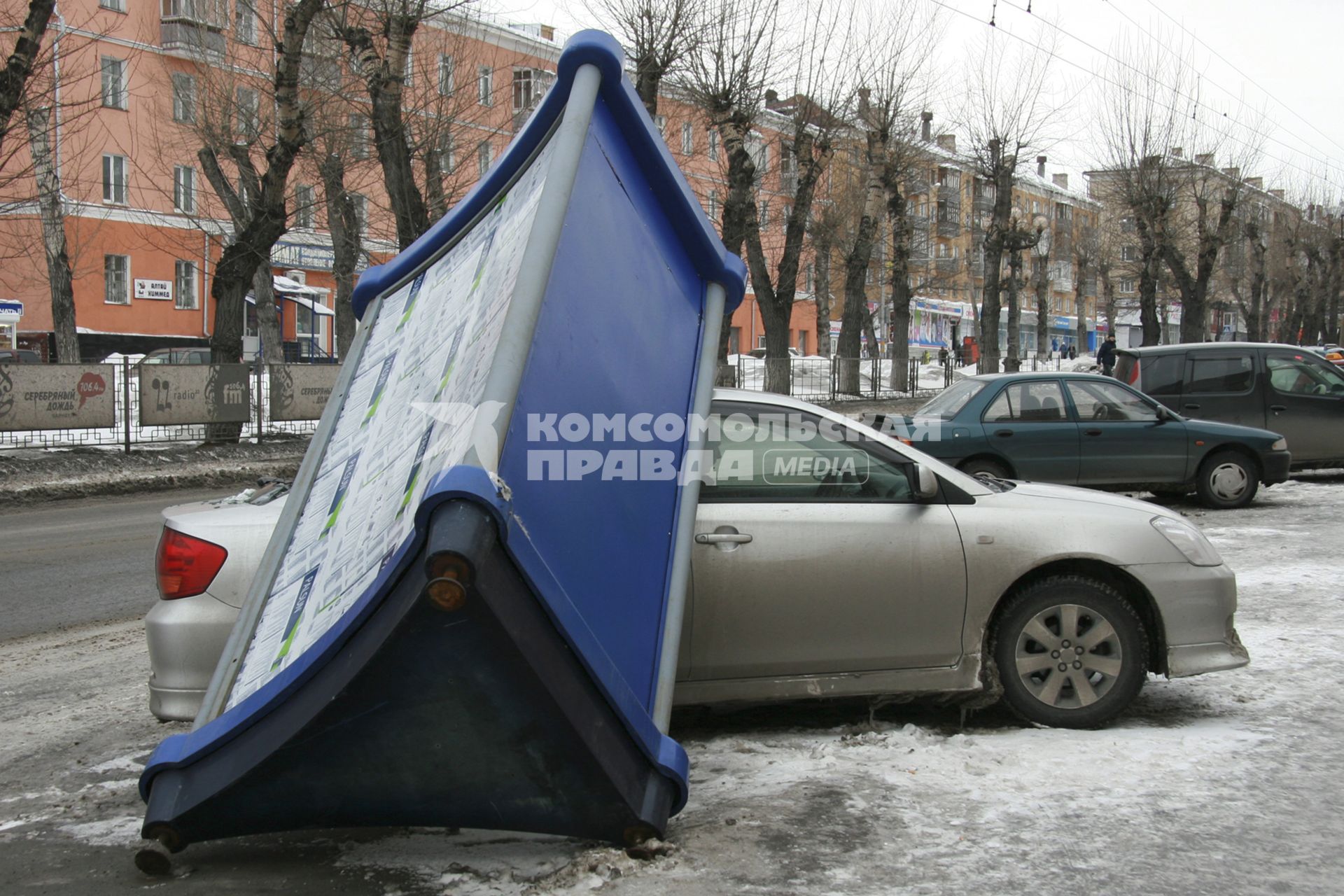 Барнаул.  Рекламная тумба, упавшая на припаркованный рядом автомобиль.