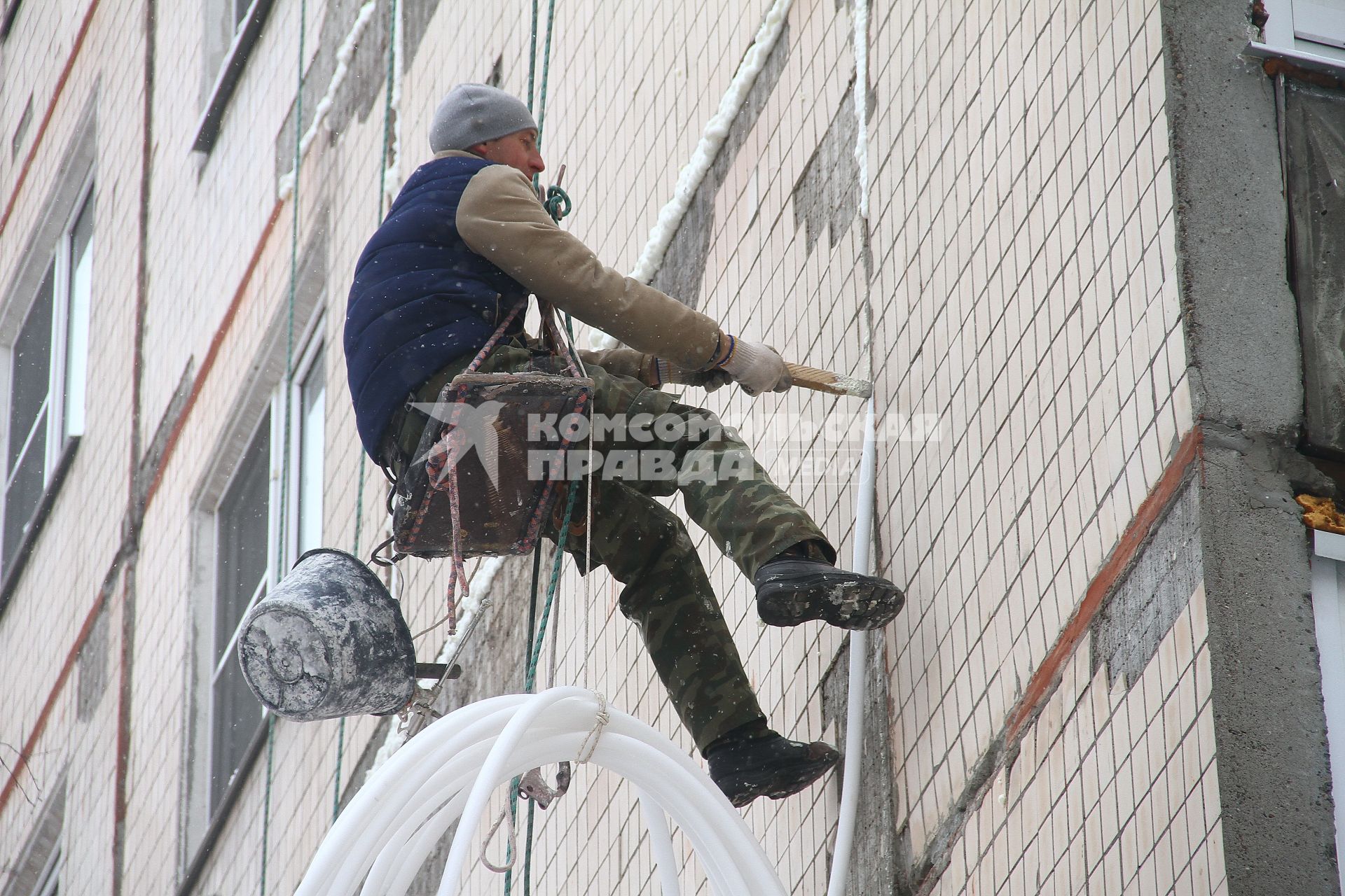 Нижний Новгород. Промышленный альпинист ремонтирует фасад жилого дома.
