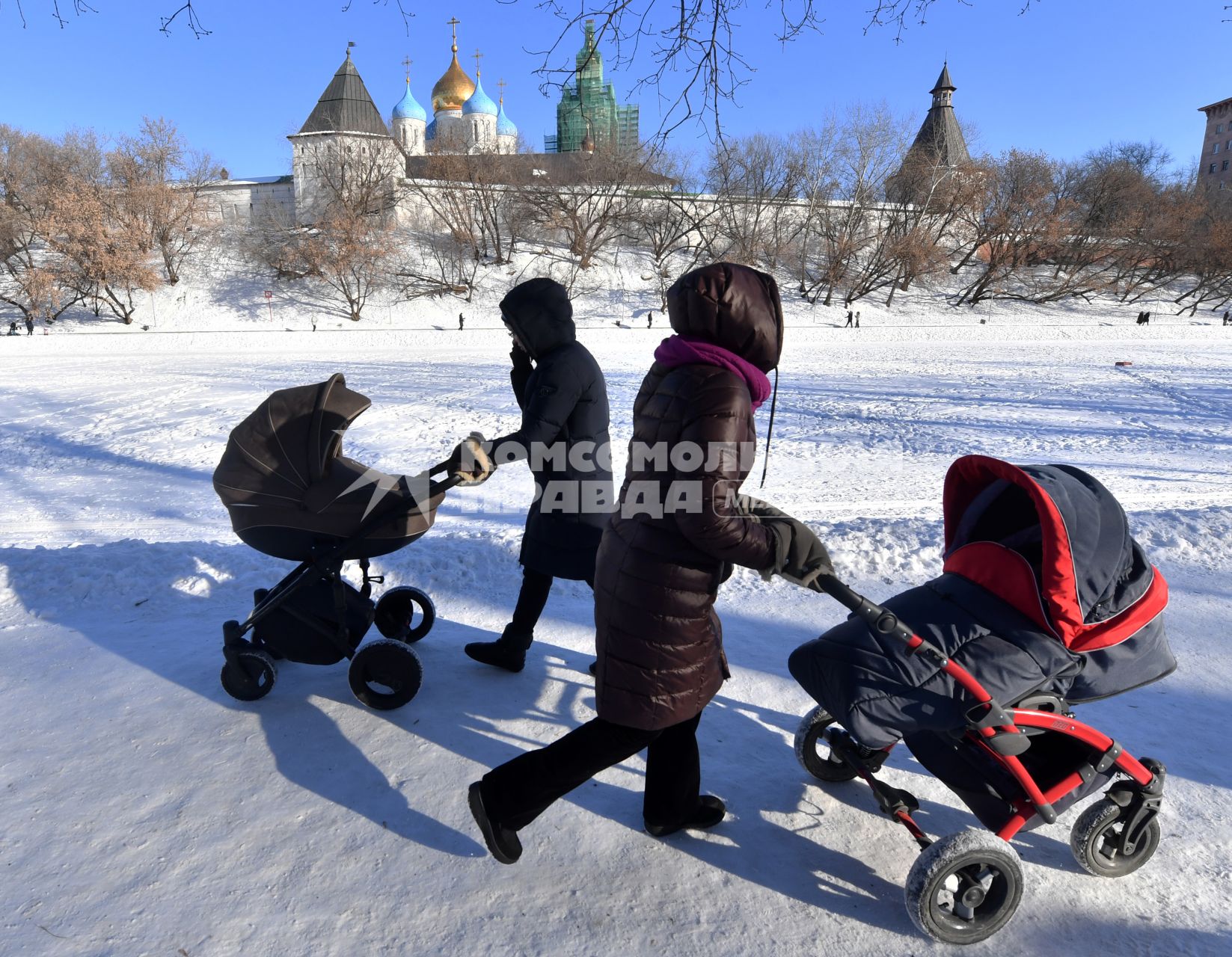 Москва. Женщины с колясками  гуляют  у стен Новоспасского монастыря.