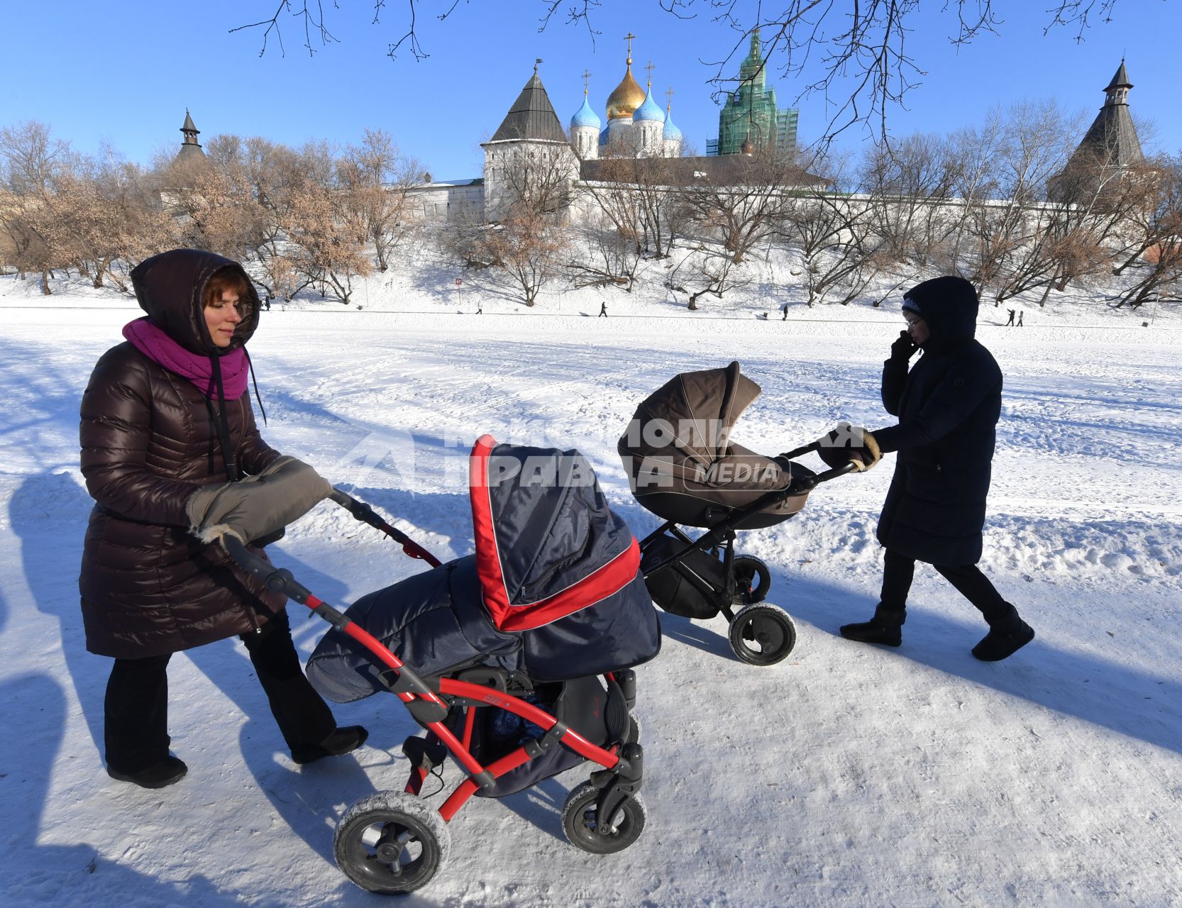 Москва. Женщины с колясками  гуляют  у стен Новоспасского монастыря.