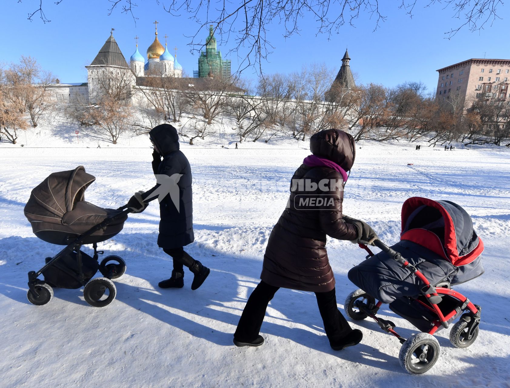 Москва. Женщины с колясками  гуляют  у стен Новоспасского монастыря.