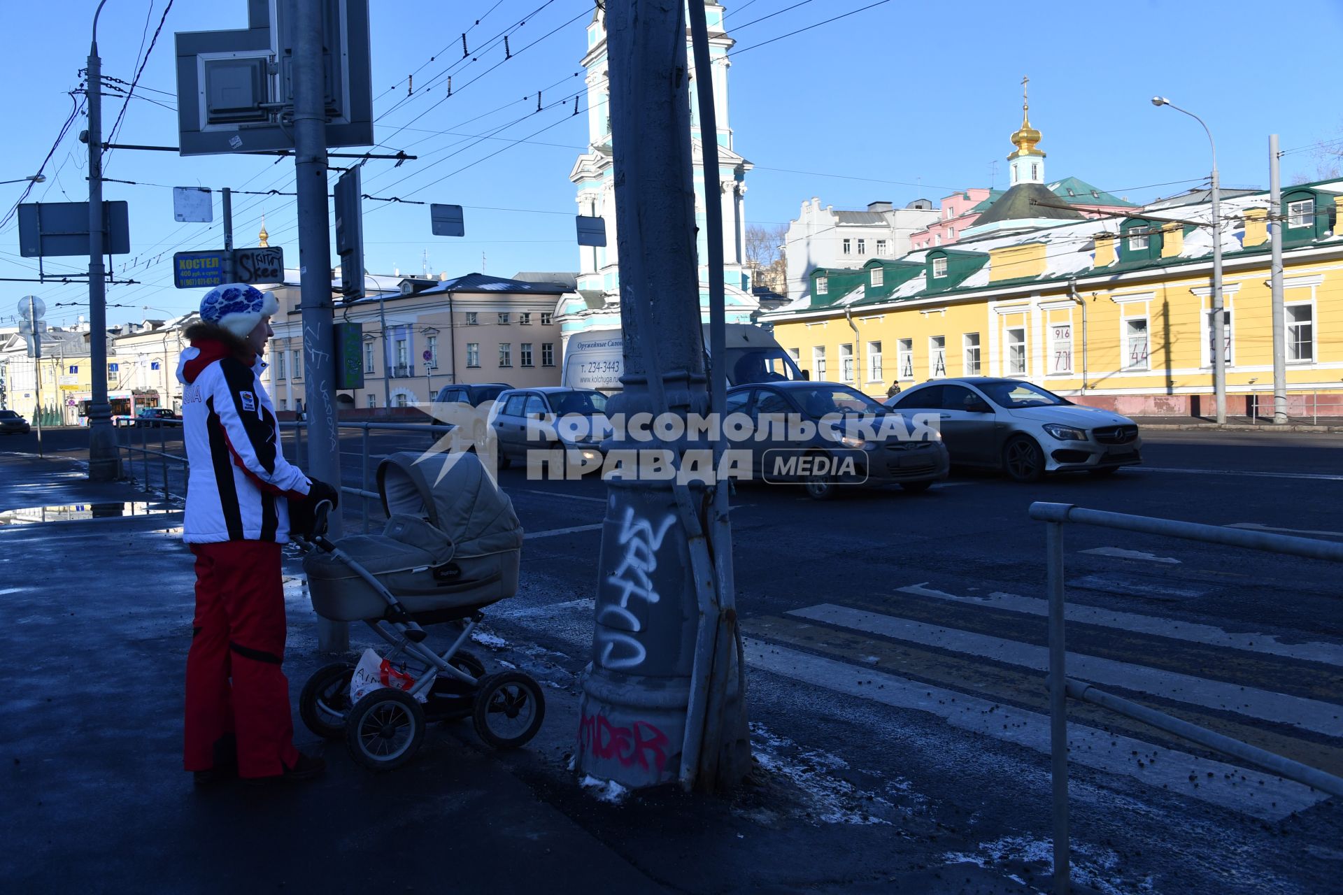 Москва.  Женщина с коляской у пешеходного перехода.