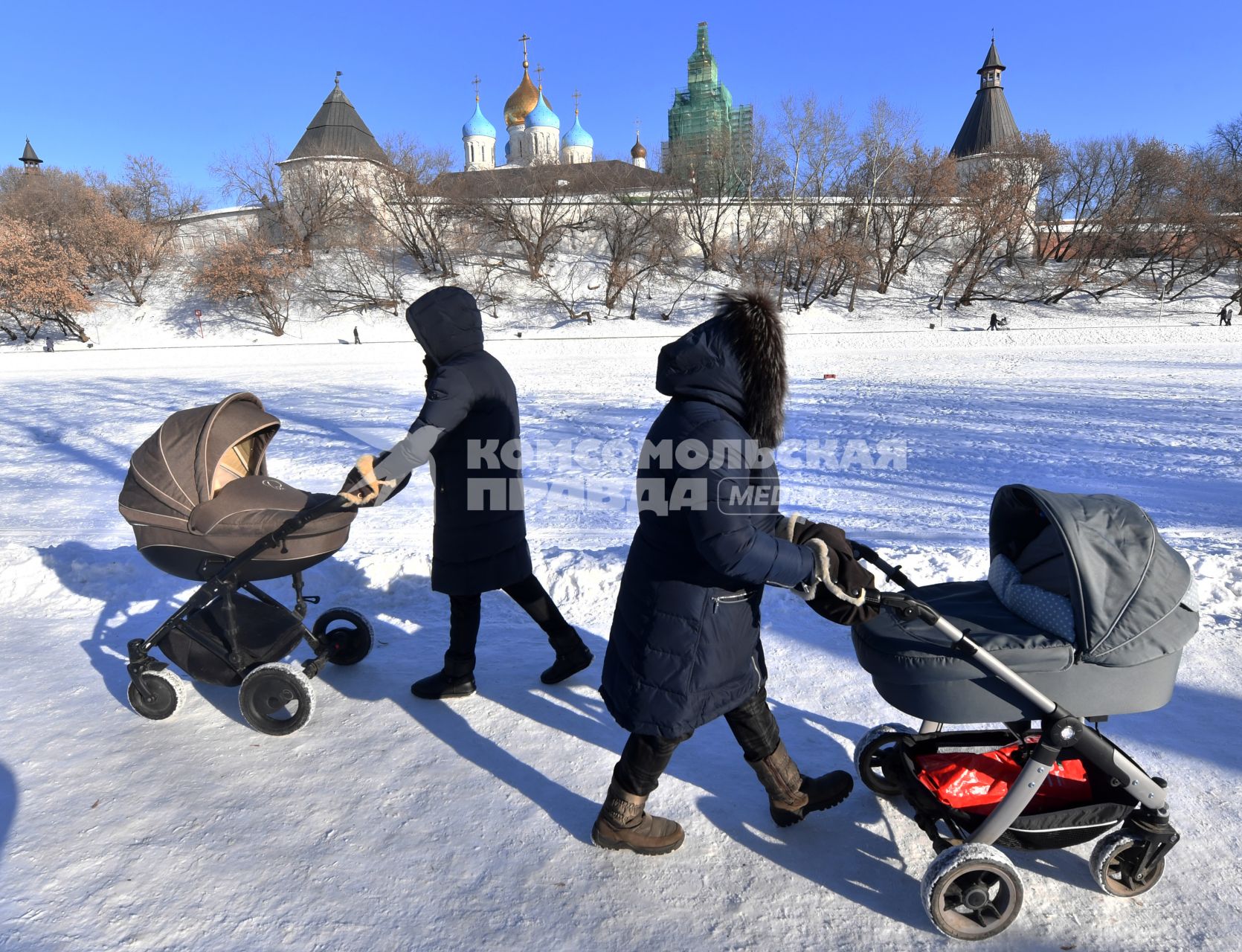 Москва. Женщины с колясками  гуляют  у стен Новоспасского монастыря.