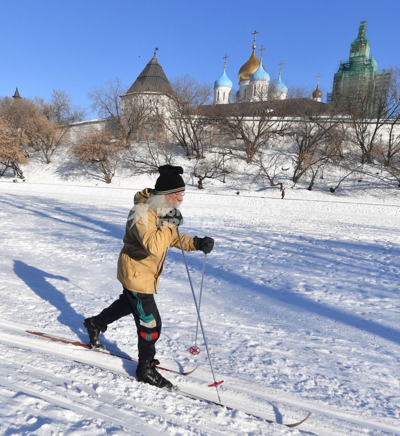 Москва. Пожилой мужчина катается на лыжах у стен Новоспасского монастыря.