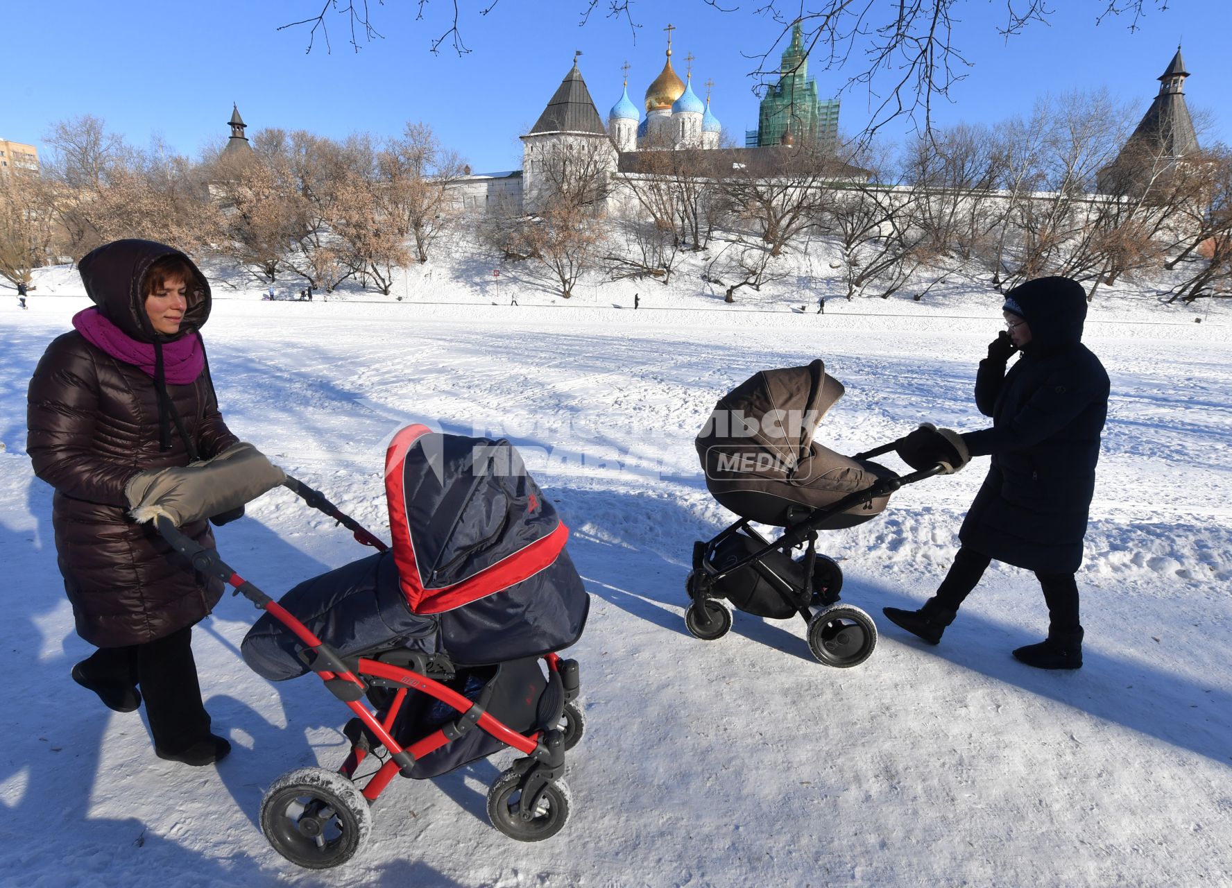 Москва. Женщины с колясками  гуляют  у стен Новоспасского монастыря.