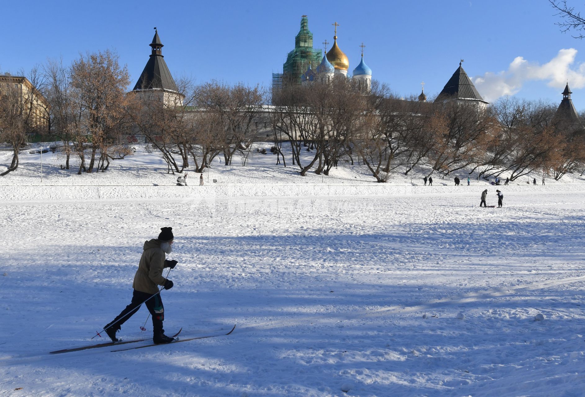 Москва. Пожилой мужчина катается на лыжах у стен Новоспасского монастыря.