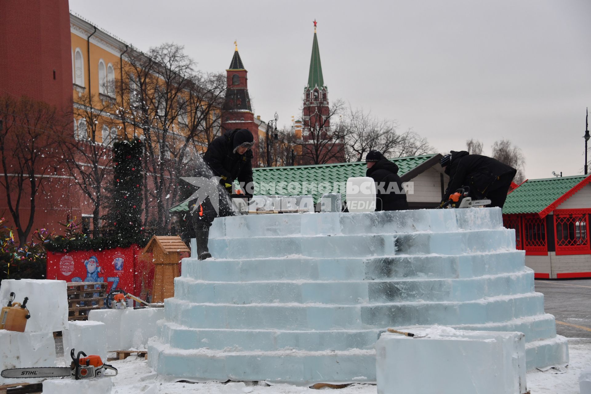 Москва.  Мужчины пилят лед на Манежной площади.