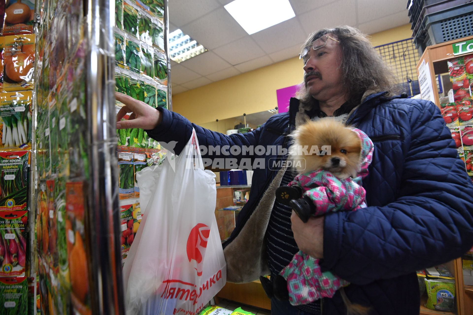 Москва.  Мужчина выбирает семена в магазине.