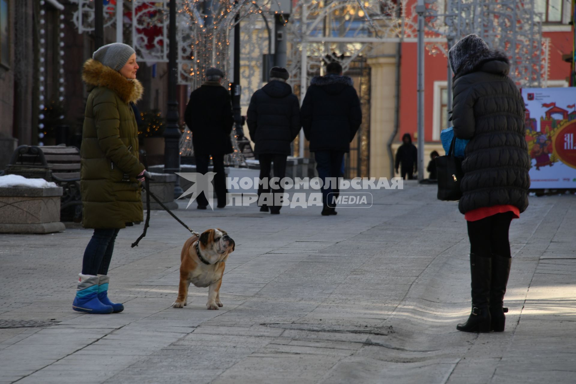 Москва.   Женщина с собакой породы бульдог в Столешниковом переулке.