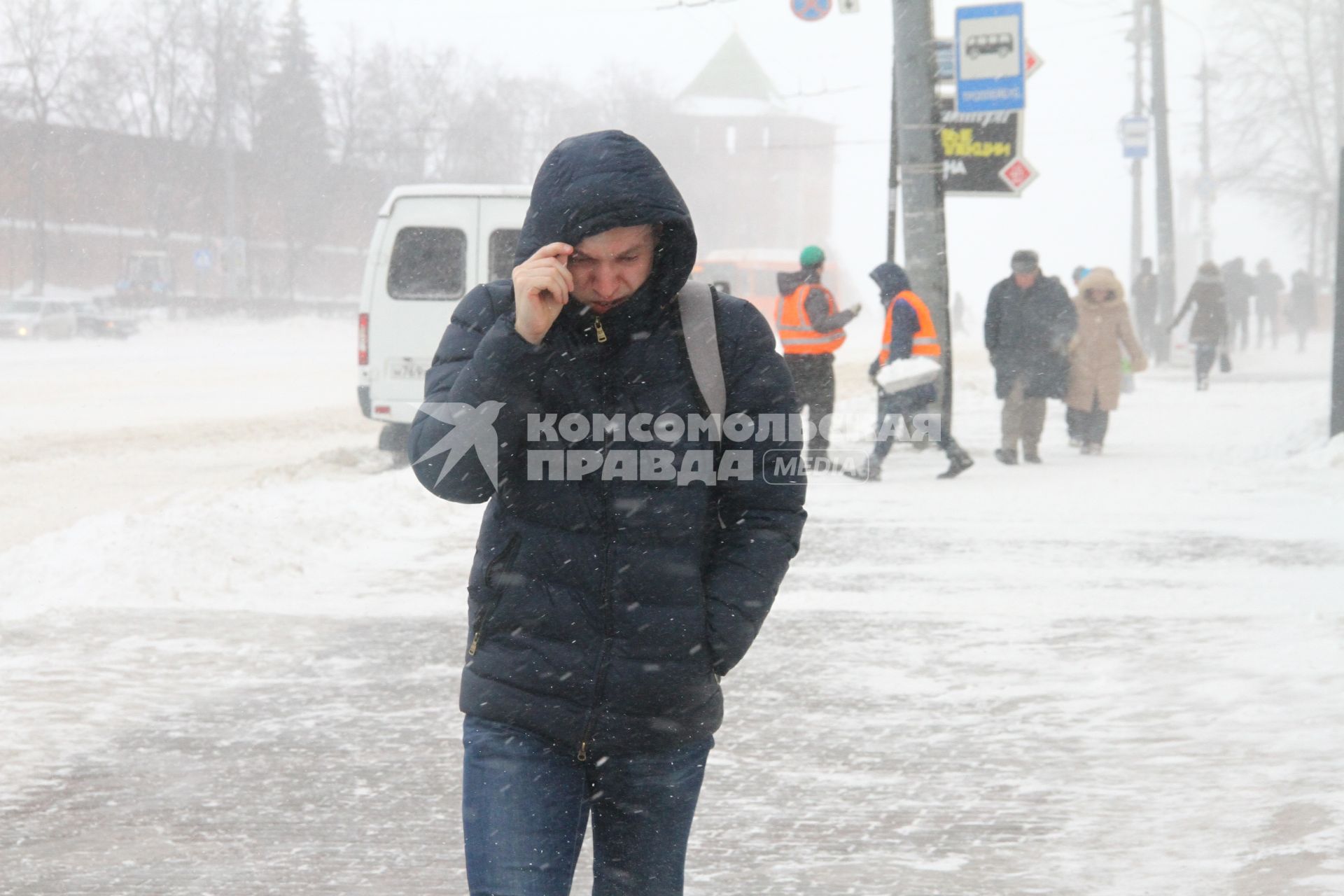 Нижний Новгород. Люди идут по  улице во время метели.