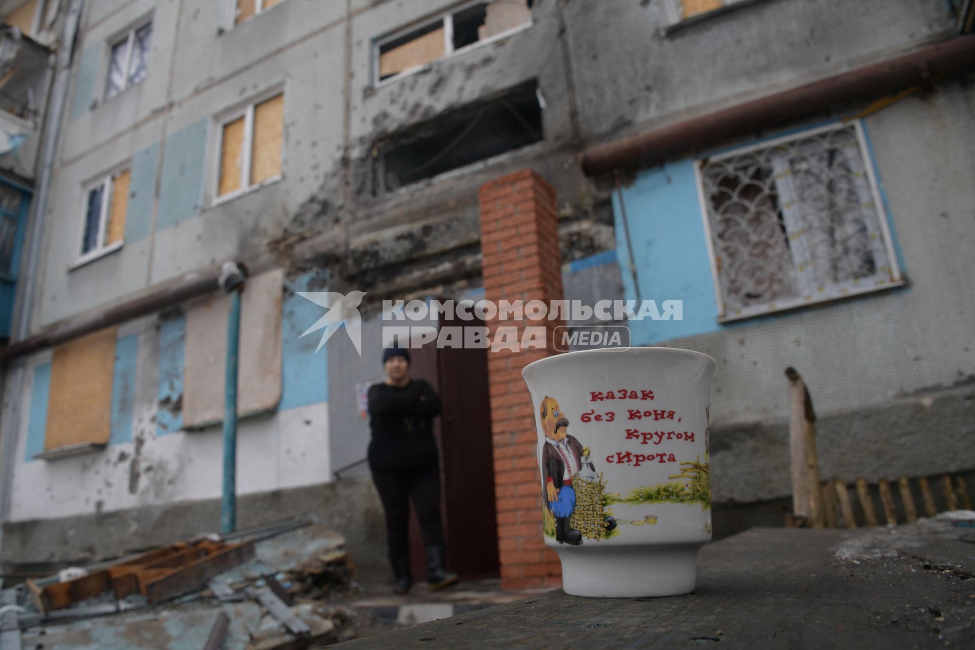 Украина, Донецк. Жилой дом в Киевском районе, пострадавший в результате артиллерийского обстрела украинскими силовиками. На переднем плане кружка с надписью `Казак без коня - кругом сирота`.