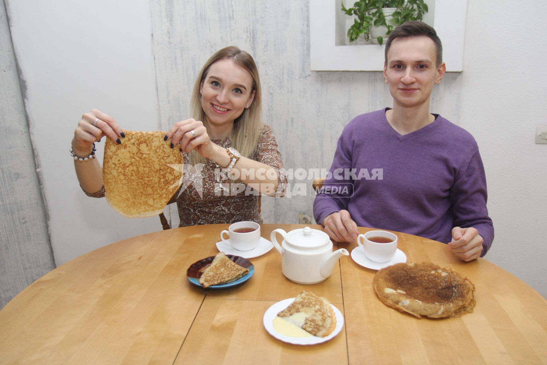 Иркутск. Молодой человек и девушка пьют чай с блинами.