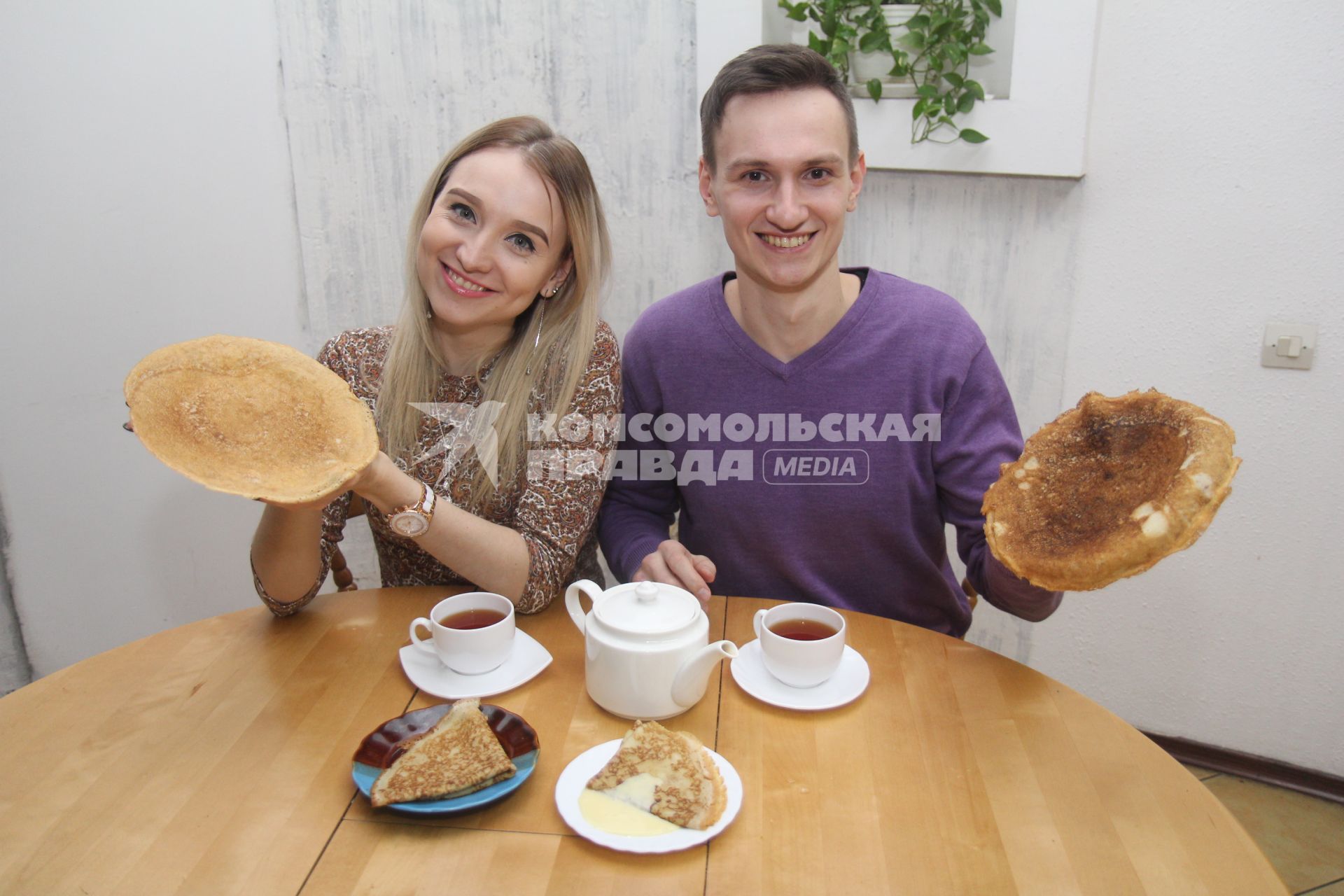Иркутск. Молодой человек и девушка пьют чай с блинами.